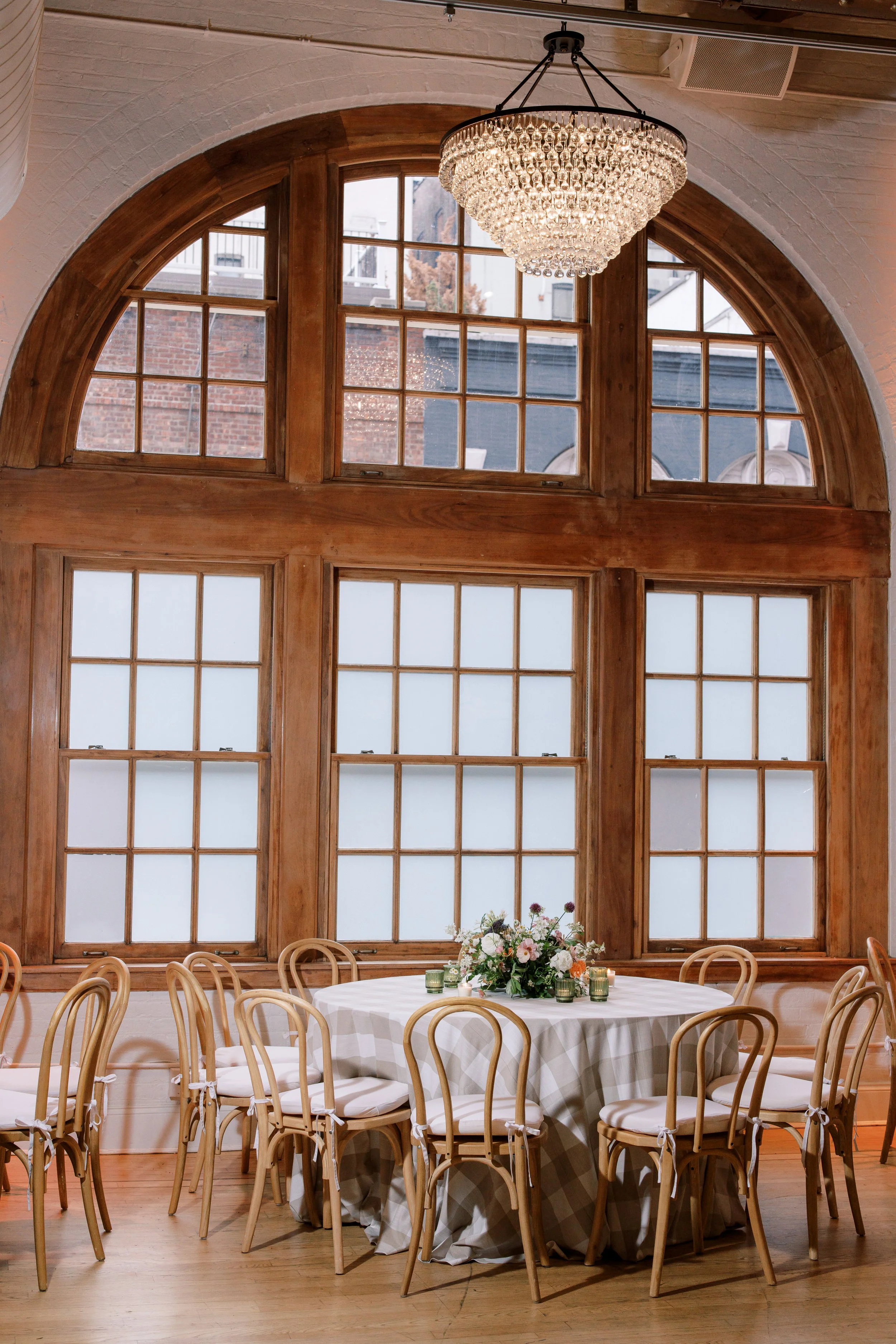 Intimate reception table with bentwood chairs and soft neutral florals inside the Altman Building in Chelsea NYC.