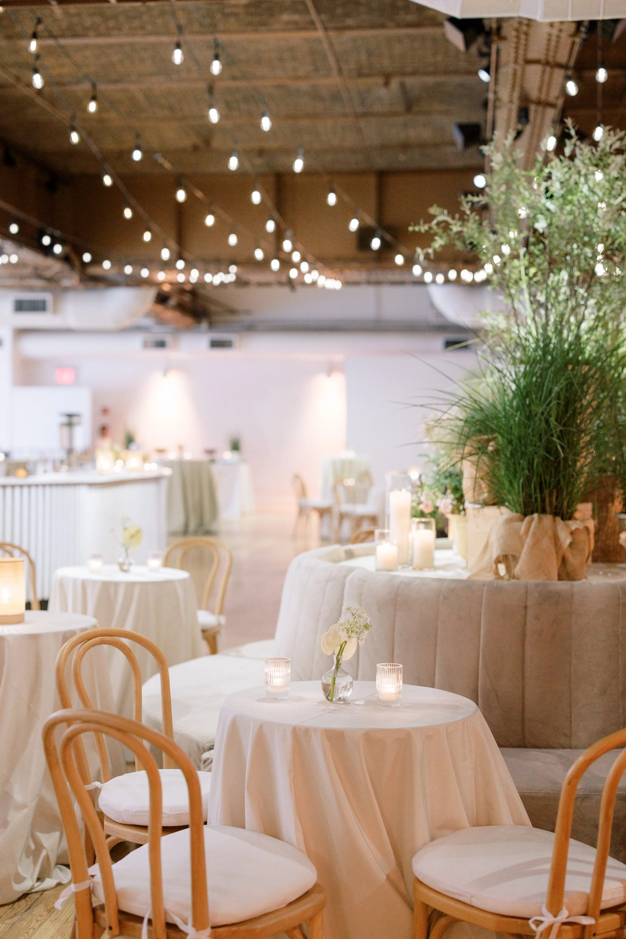 Chelsea NYC wedding reception at the Altman Building with soft neutral linens, natural greenery, and warm lighting.