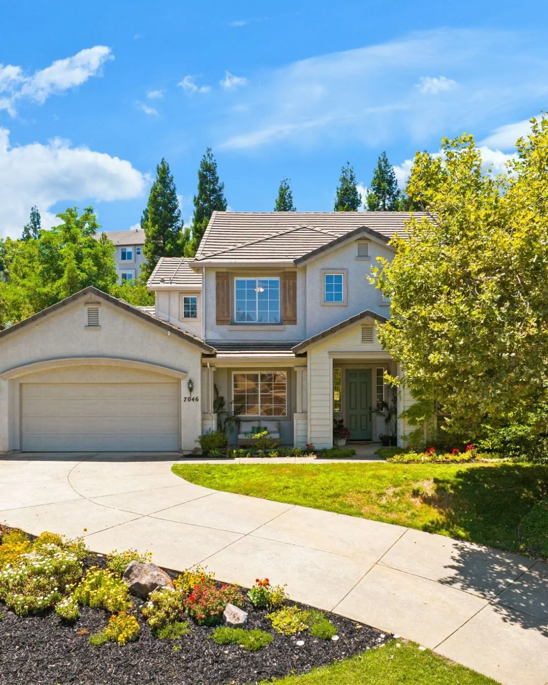Two-story suburban home with landscaped front yard, curved driveway, and attached garage in El Dorado Hills, California.