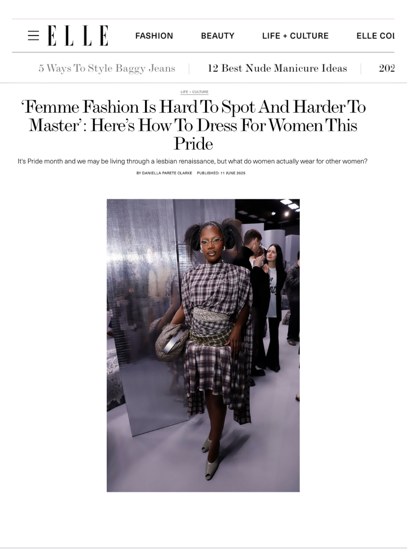 Close-up of a person wearing a black jacket, a dark red zip-up sweater, a brown scarf with pink patterns, and a blue checkered skirt.