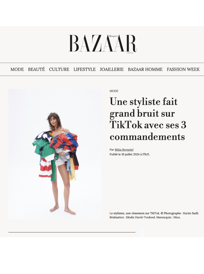 A woman wearing a black blazer and high heels walking outside a modern building with glass and brick walls.