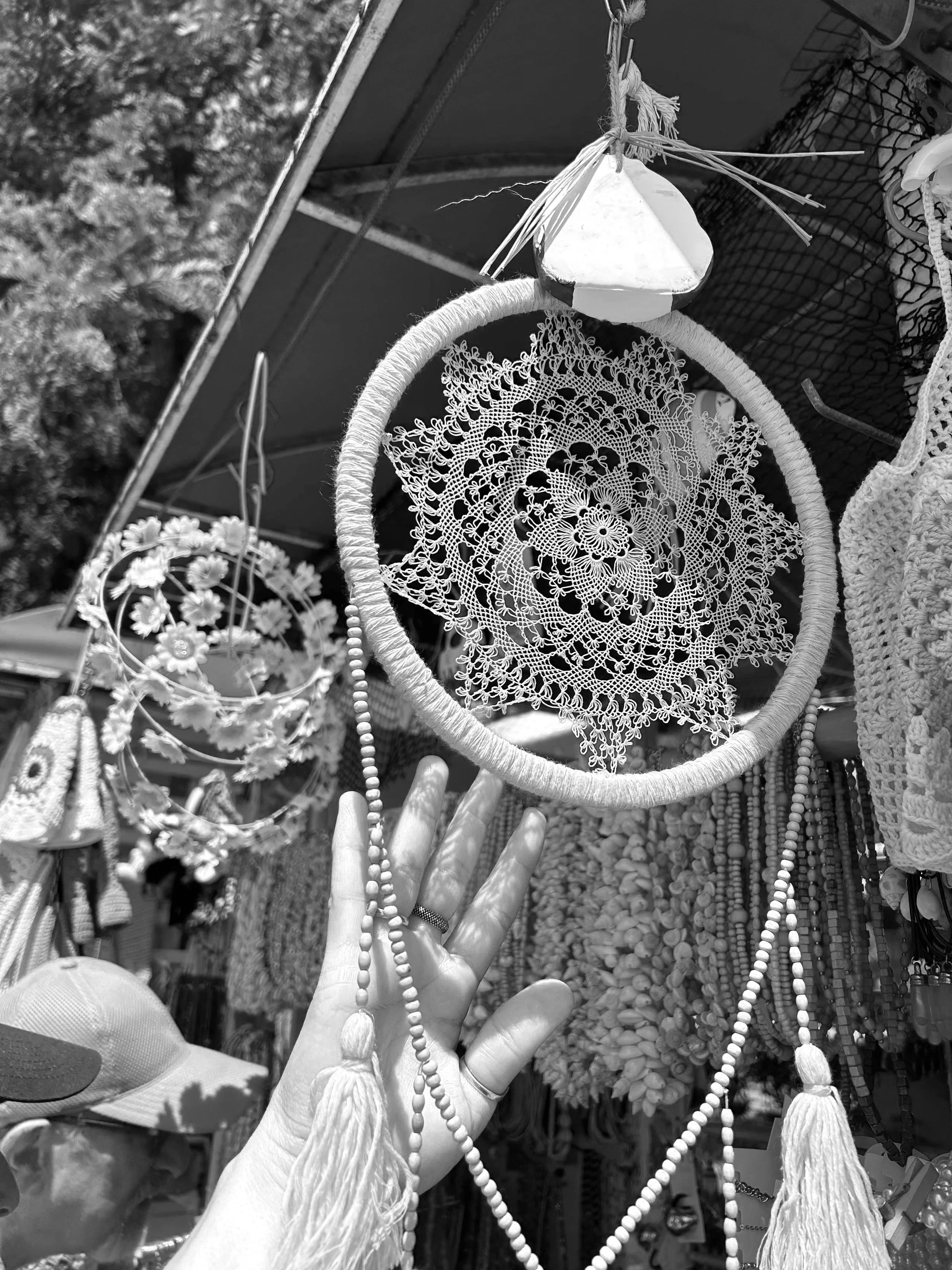 Black and white photo of needlelace doily on display at open-air market