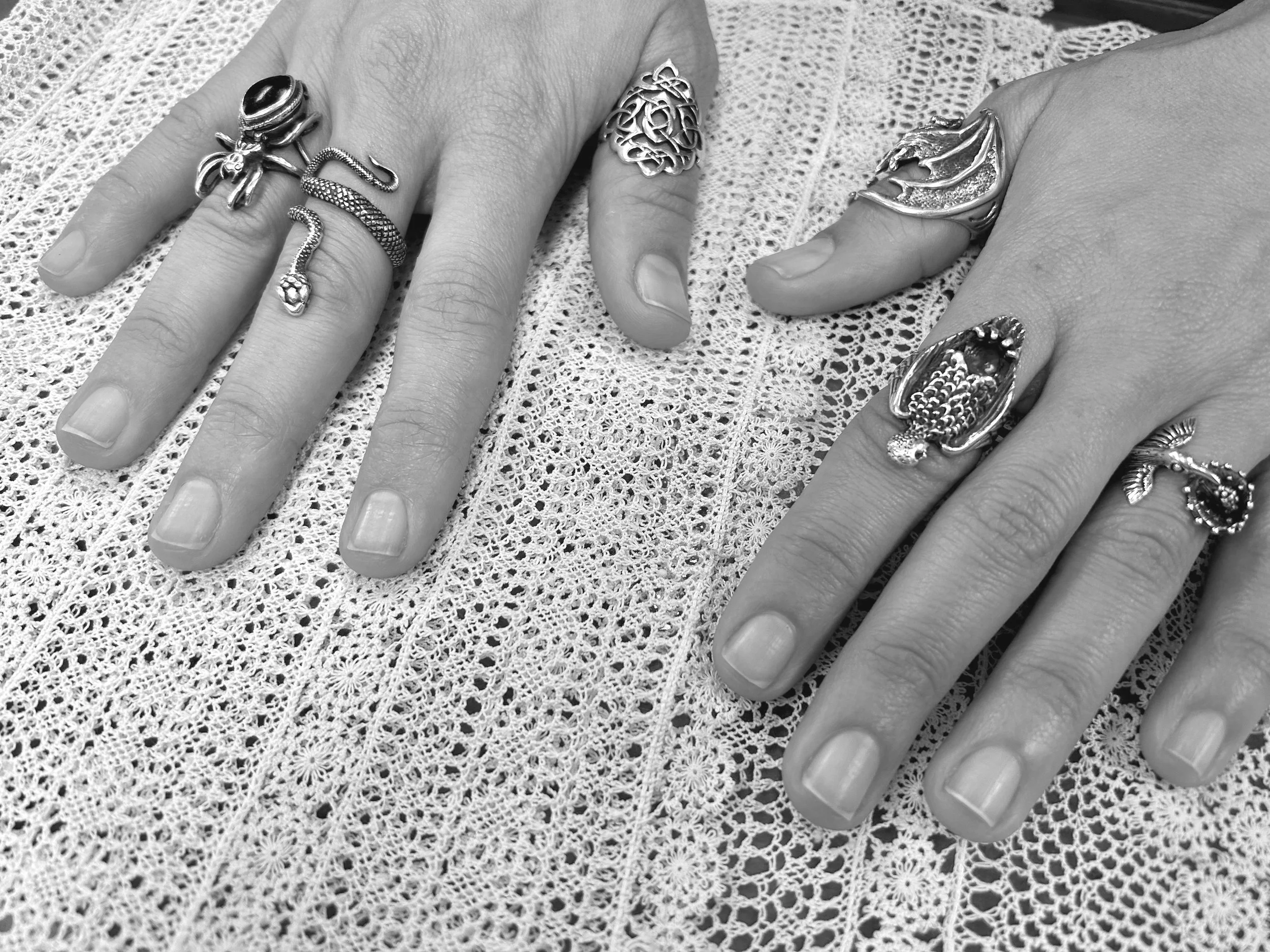 Black and white photo of Armenian needlelace garment and person's hands