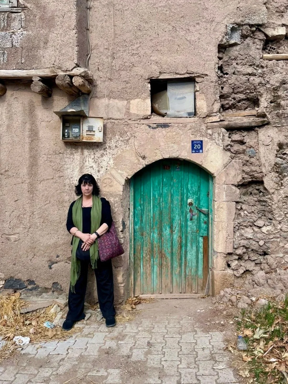 Armenian Needlelace Initiative co-founder Deborah Valoma standing in front of stone structure with green door
