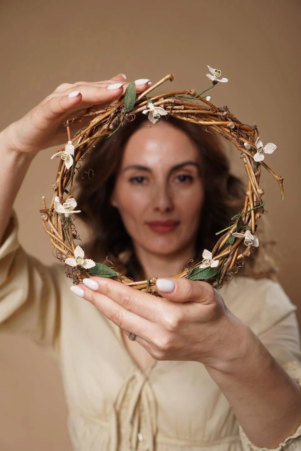 Iskuhi Sargsyan, posing with a headdress of twigs and needlelace flowers intertwined, Yerevan, Armenia. Photo: © Iskuhi Sargsyan 2026.