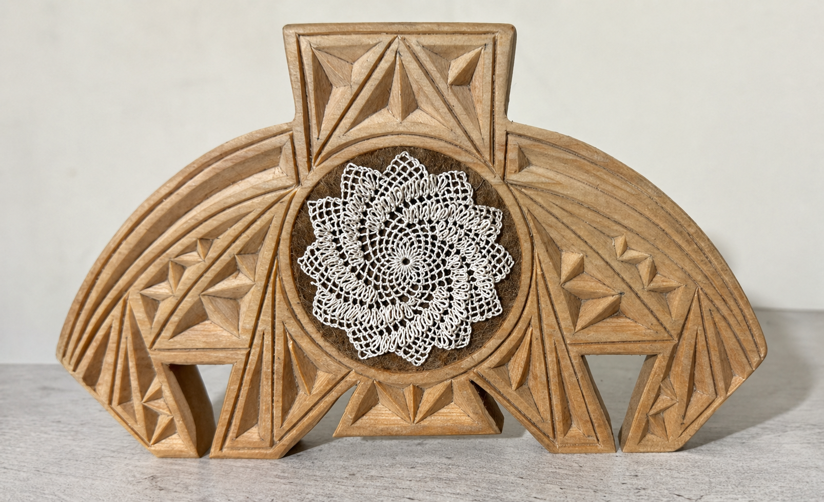 Maral Sheuhmelian, needlelace medallion with a central արեւախաչ ( arevakhach ,"sun cross") gracing the center of a wooden դաղդղան ( daghdghan ), a traditional carved Armenian amulet, Yerevan, Armenia, 2022. The arevakhach is a symbol of eternity foun