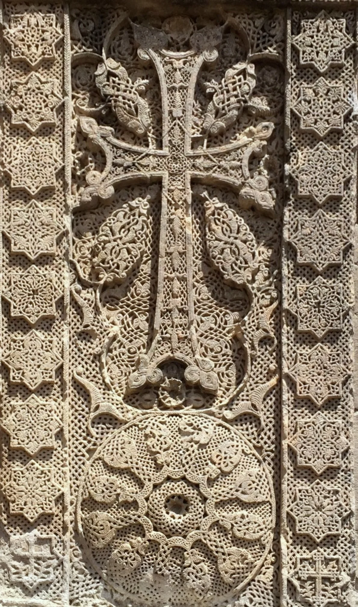 Intricately carved, cream-colored Armenian khachkar (cross-stone)