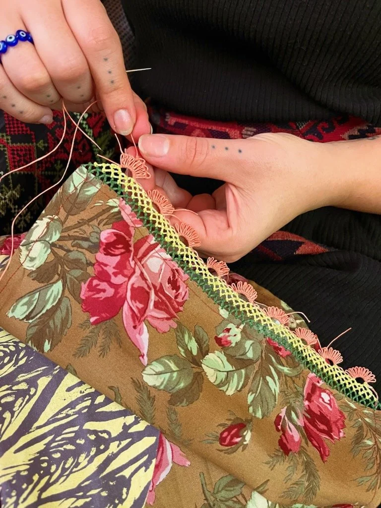 Ali Cat, janyak border-in-process, linen thread on cotton fabric, Portland, Oregon, 2025. Janyak border added to a screenprinted banner at the March 2025 SWANA Stitch gathering at SWANA Rose Culture + Community Center. Photo credit: © Veera Suliman 2