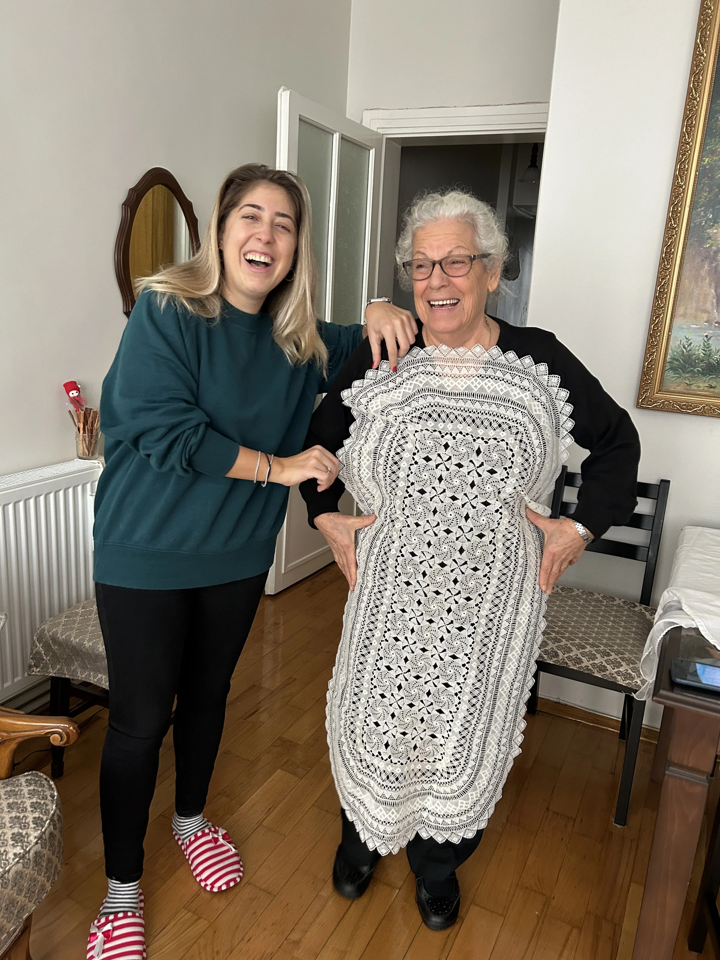 Dzaghig Chitchi and granddaughter Tais Nune Çitci Torosoğlu showing a needlelace table runner made for her granddaughter's trousseau, Şişli, Istanbul, Türkiye, 2023. Photo credit: © Deborah Valoma, 2023.
