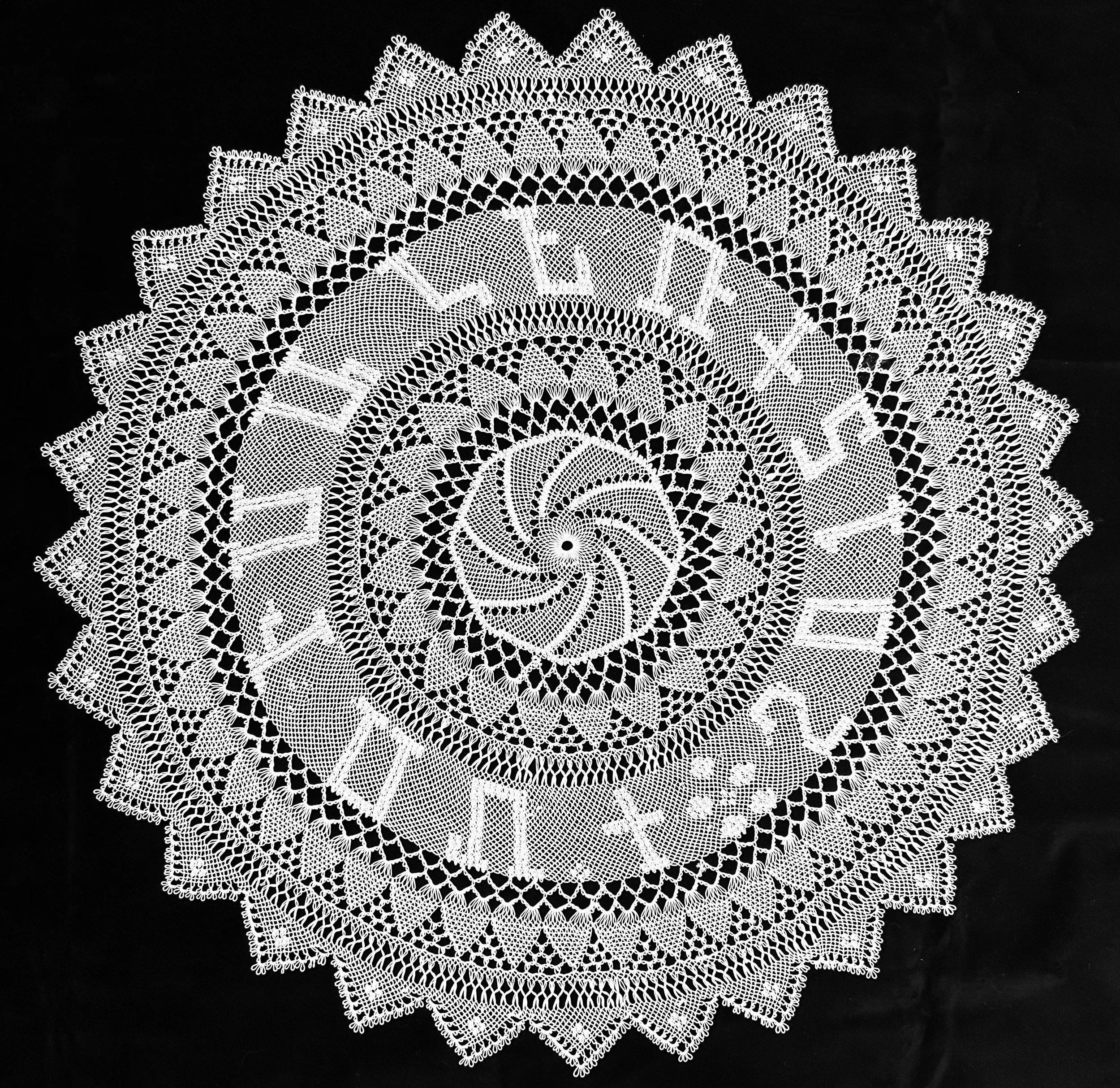 Black and white photo of Armenian needlelace doily with Armenian letters stitched in