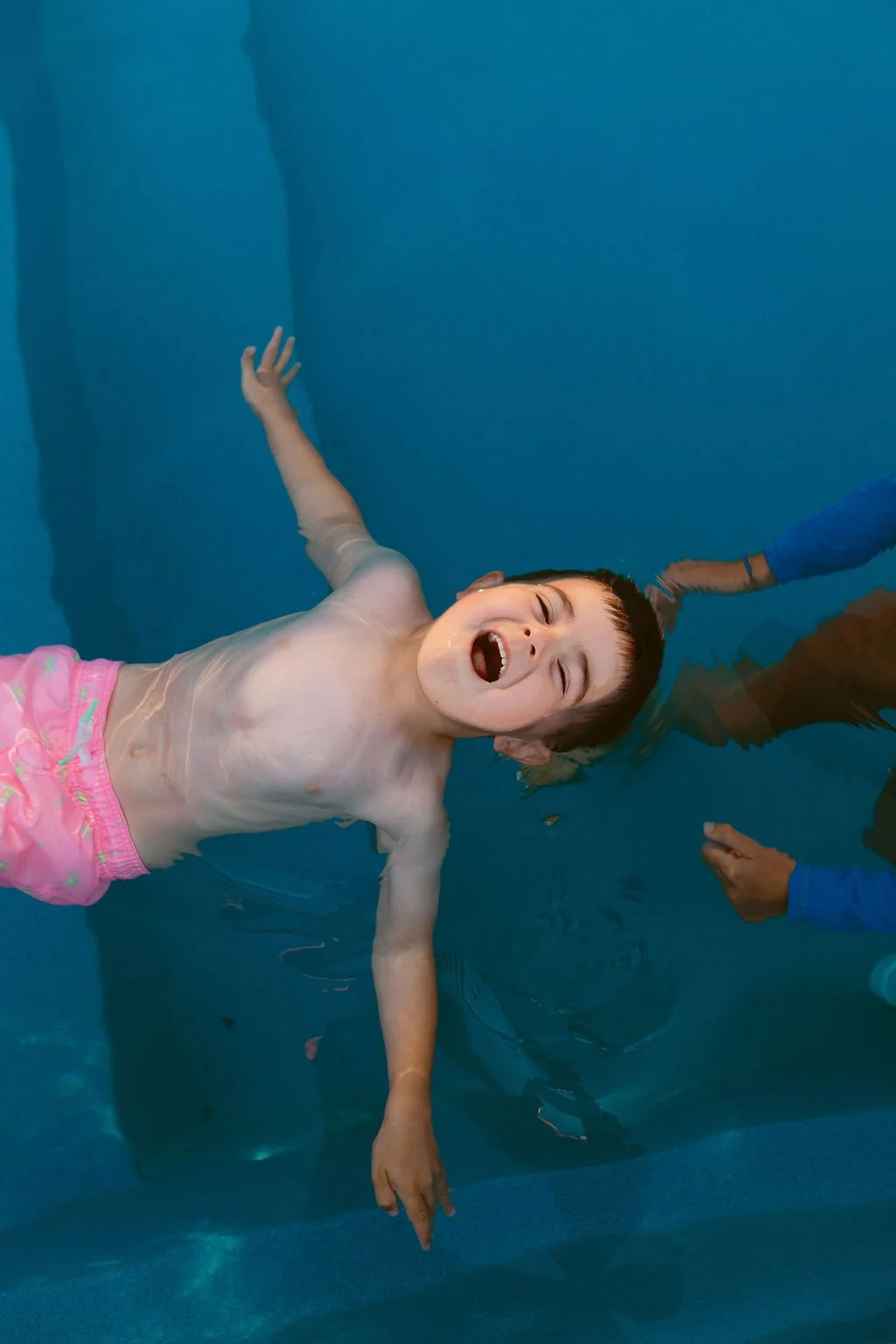 Boy learning to float on his back in water