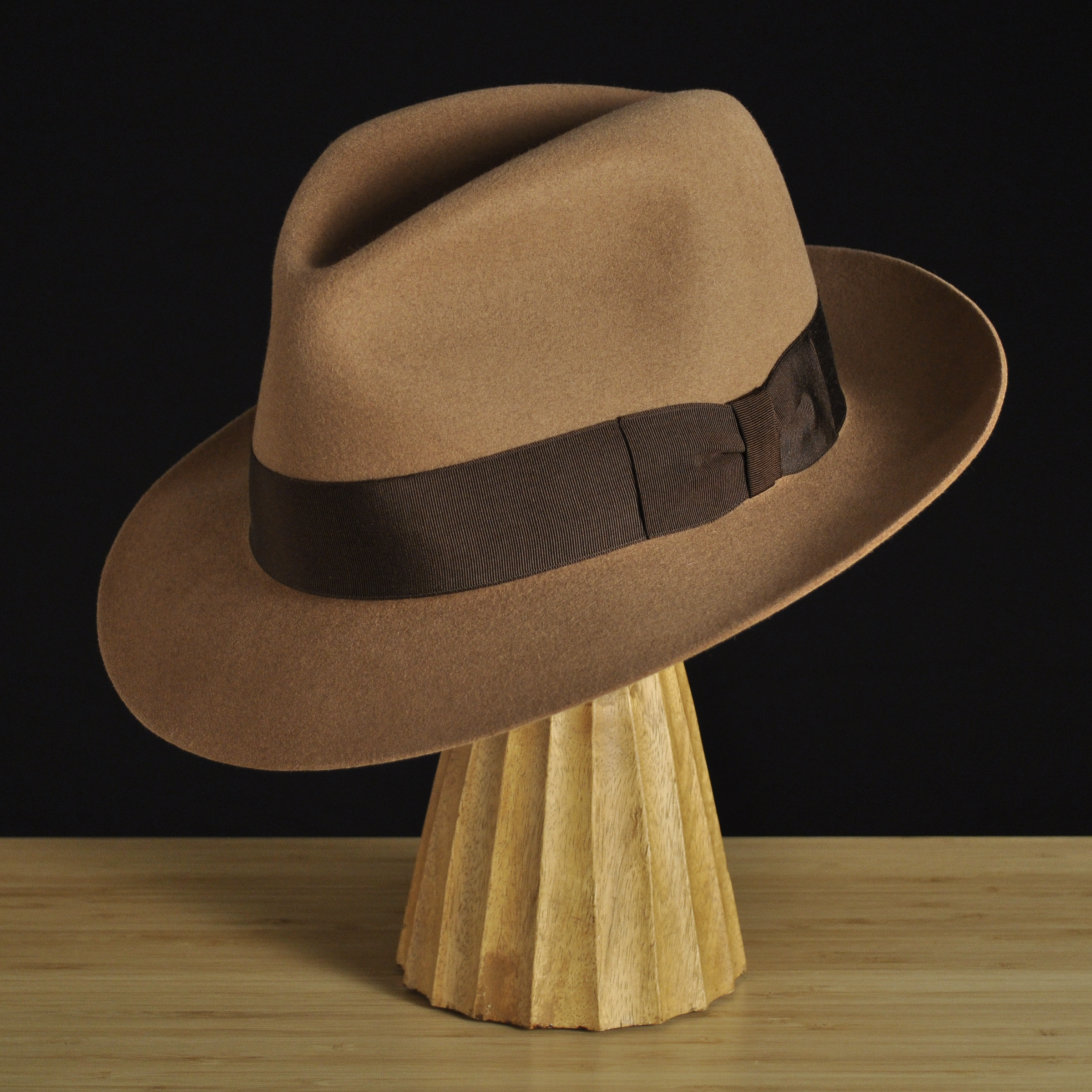 Three-quarter front left view of The Vendômer tan felt fedora with a softly pinched crown, medium snap brim, and dark brown grosgrain ribbon with classic bow.