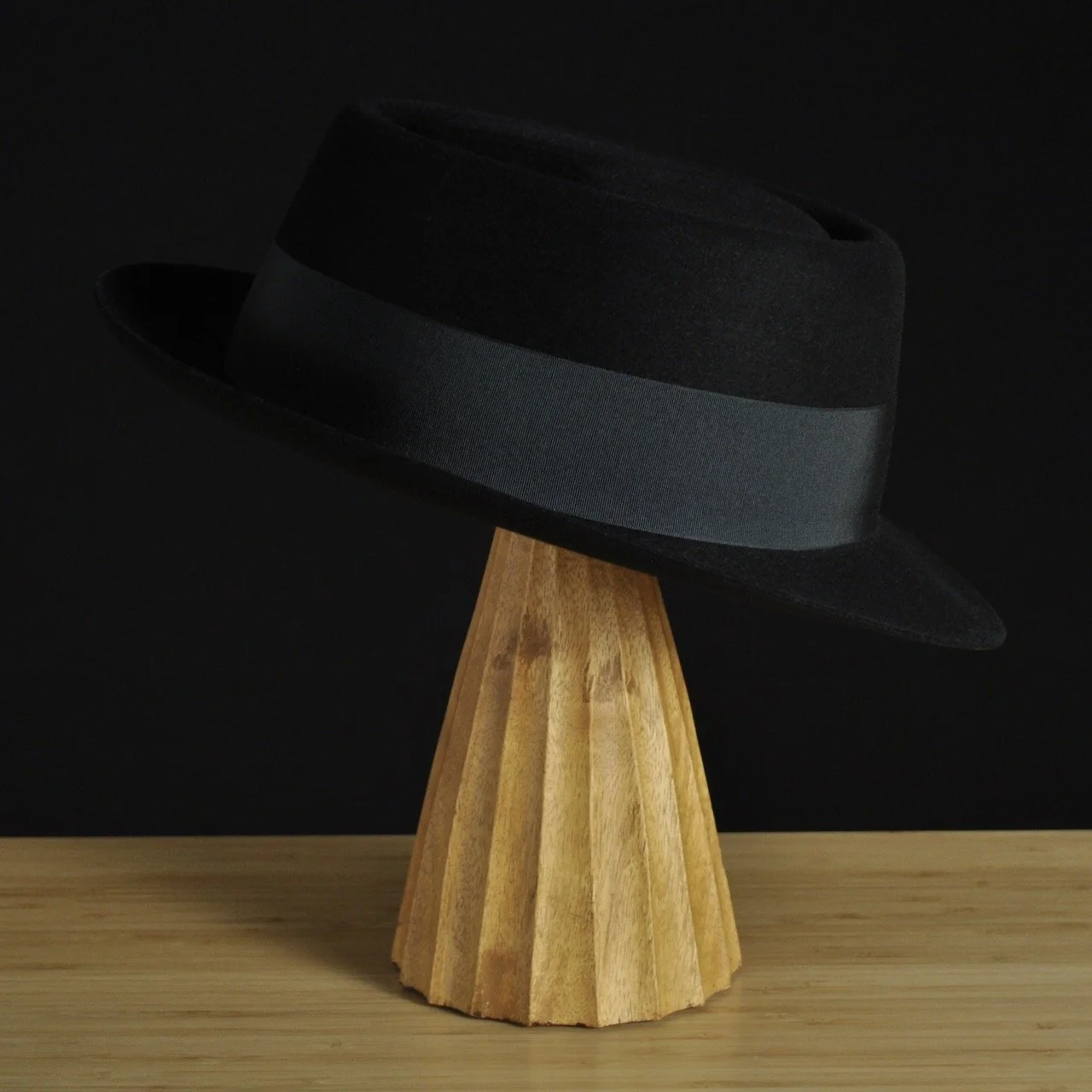 - Right view of The Midtowner black felt fedora with a clean tapered crown, medium snap brim, and matching black grosgrain ribbon with classic bow.
