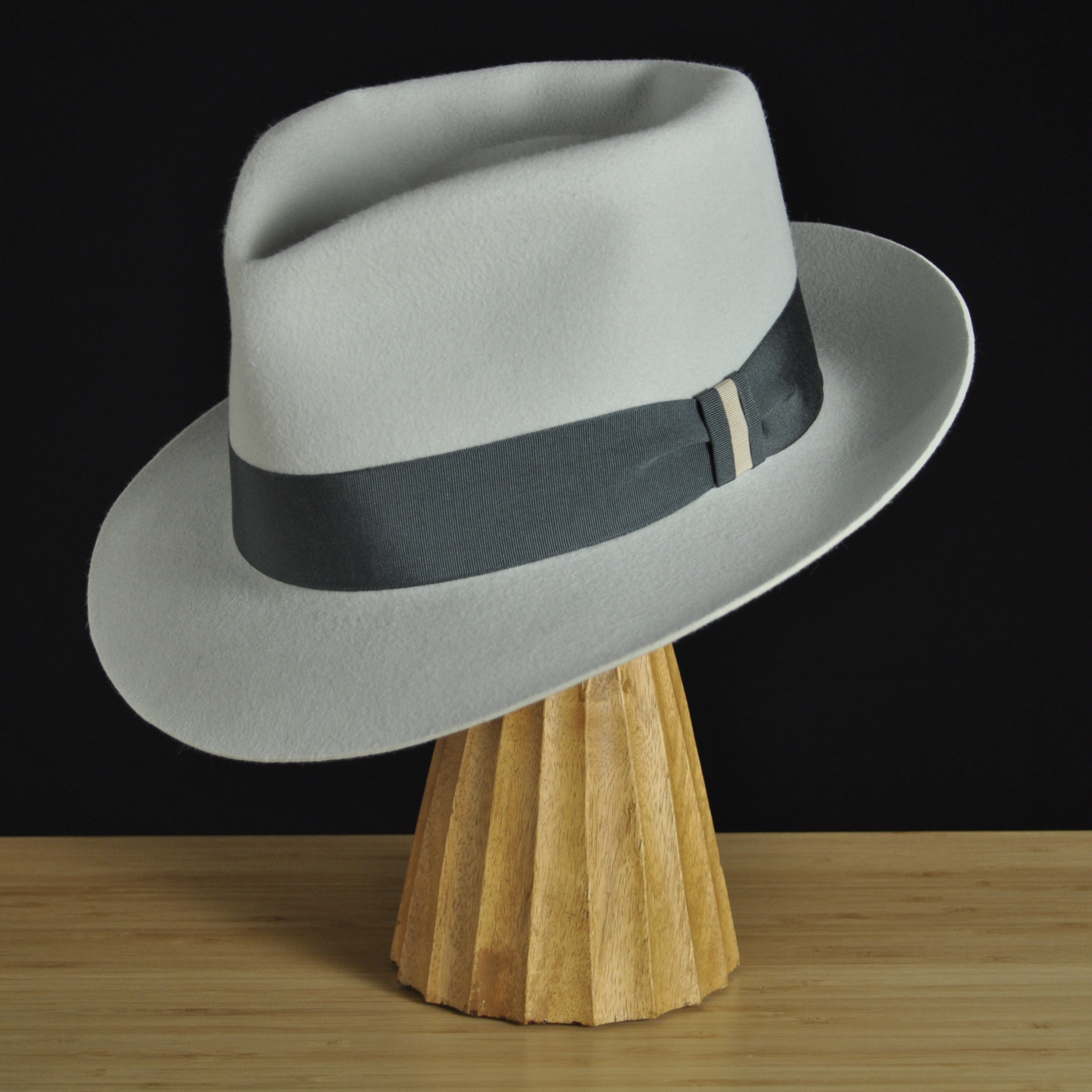 Three-quarter front left view of The Sunsetter silvermist felt fedora with a softly pinched crown, medium snap brim, and contrasting dark grosgrain ribbon with a modern tie (no bow).