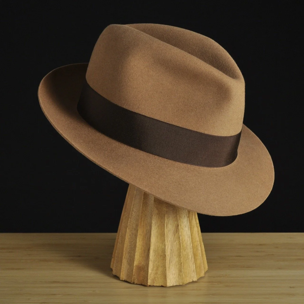 Three-quarter front right view of The Vendômer tan felt fedora with a softly pinched crown, medium snap brim, and dark brown grosgrain ribbon with classic bow.