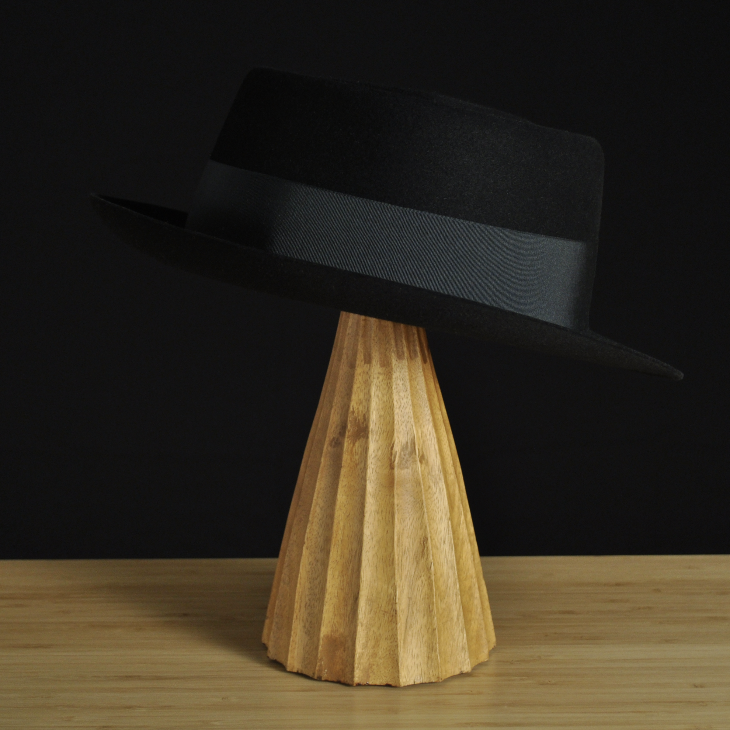Three-quarter rear right view of The Midtowner black felt fedora with a clean tapered crown, medium snap brim, and matching black grosgrain ribbon with classic bow.