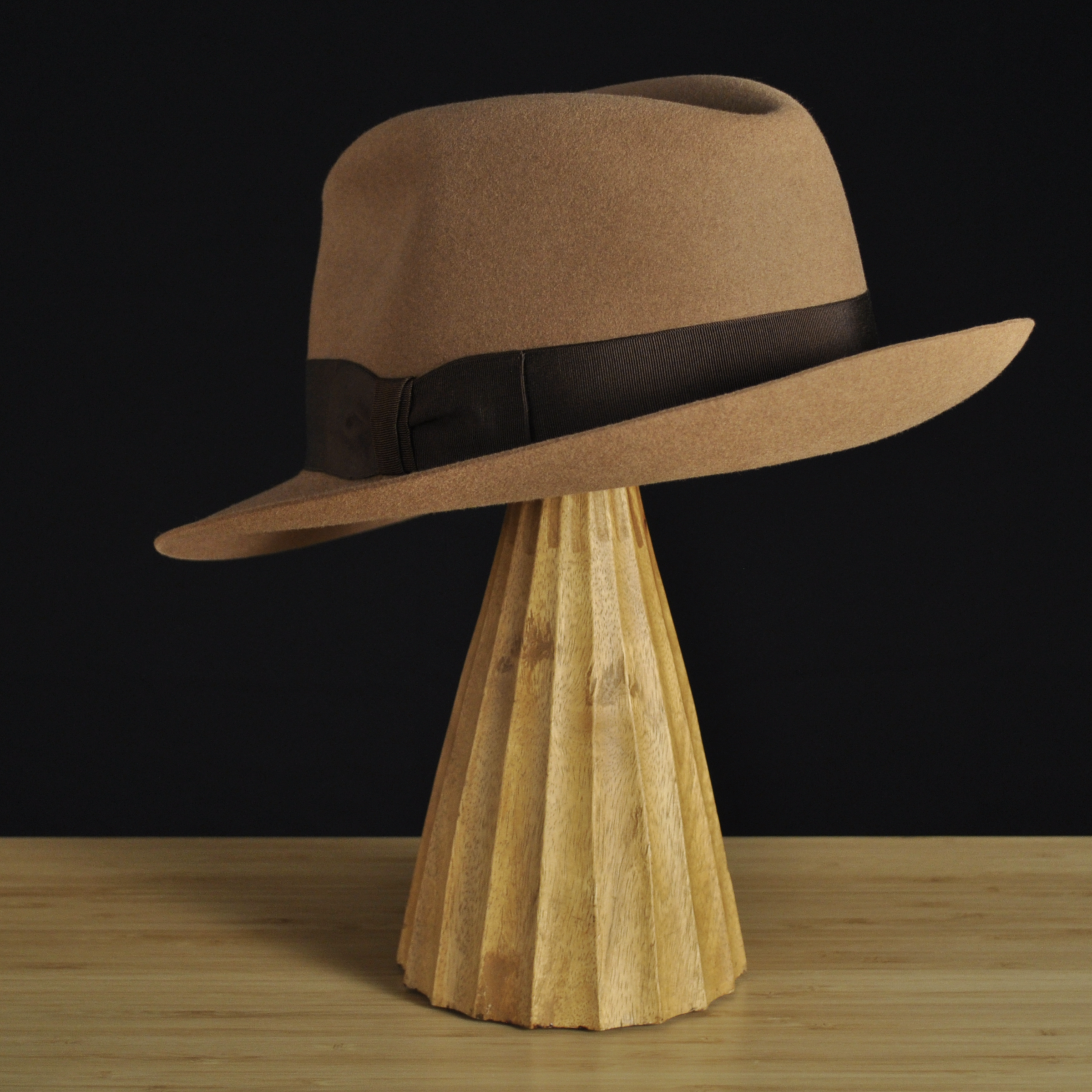 Three-quarter rear left view of The Vendômer tan felt fedora with a softly pinched crown, medium snap brim, and dark brown grosgrain ribbon with classic bow.