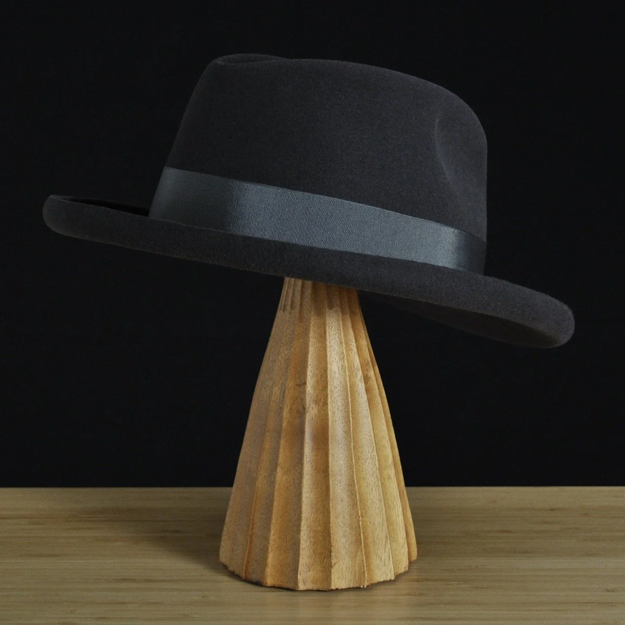 Vista trasera a tres cuartos del sombrero de fieltro antracita «The Westminster», con copa estructurada, ala rizada y cinta de grosgrain a juego con un clásico lazo doble.