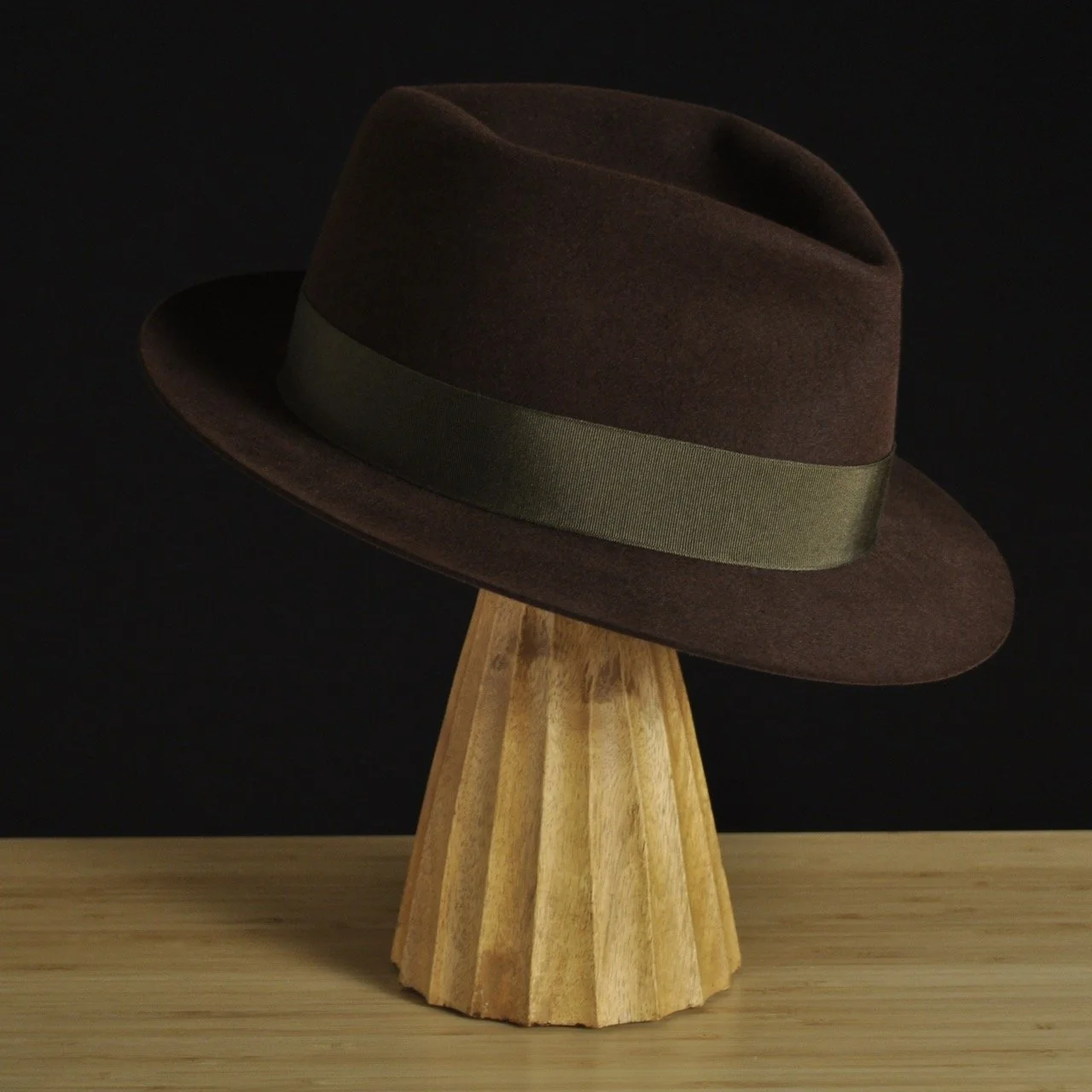 - Three-quarter front right view of The Hielander brown felt fedora with a softly pinched crown, medium snap brim, and olive grosgrain ribbon with classic bow.
