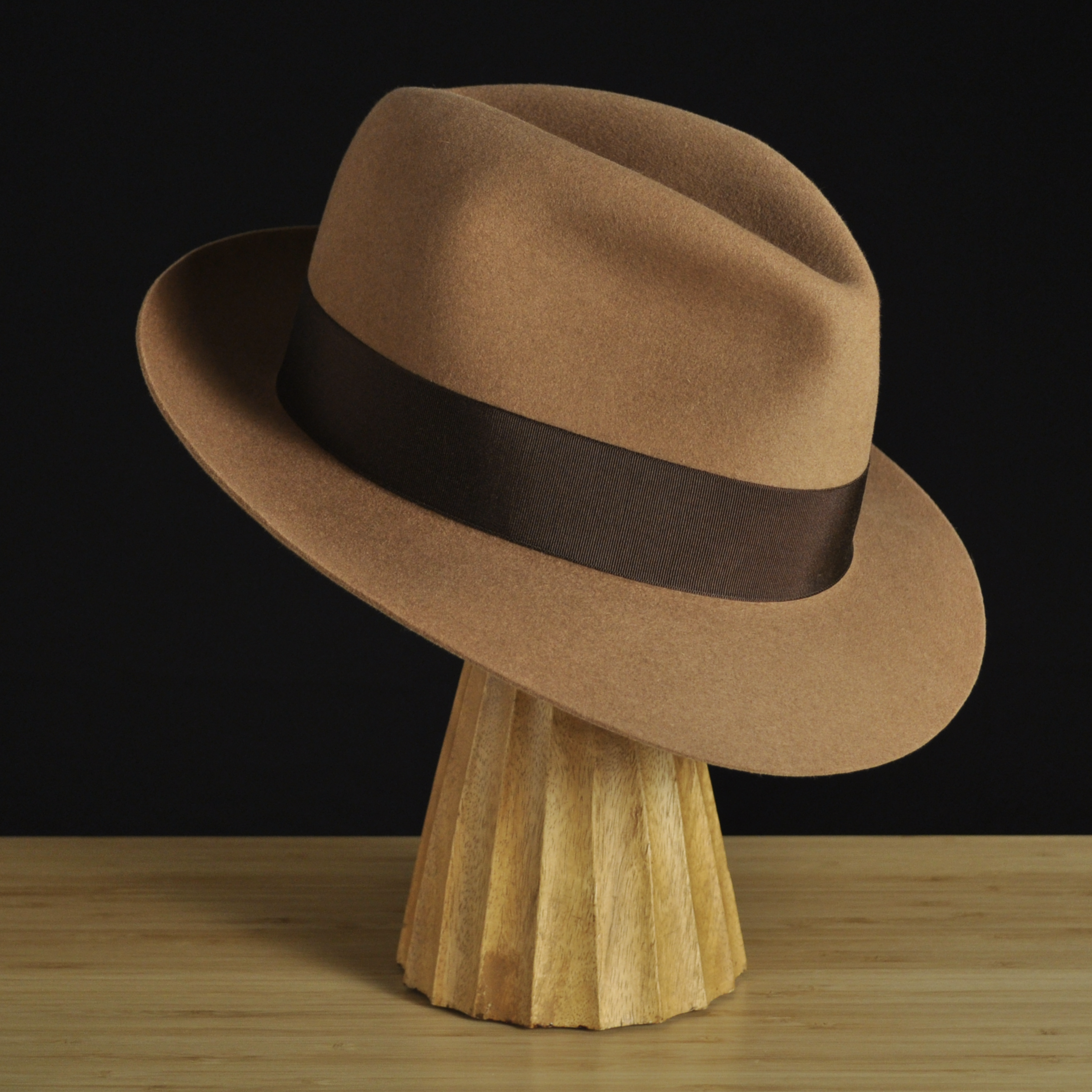 Three-quarter front right view of The Vendômer tan felt fedora with a softly pinched crown, medium snap brim, and dark brown grosgrain ribbon with classic bow.