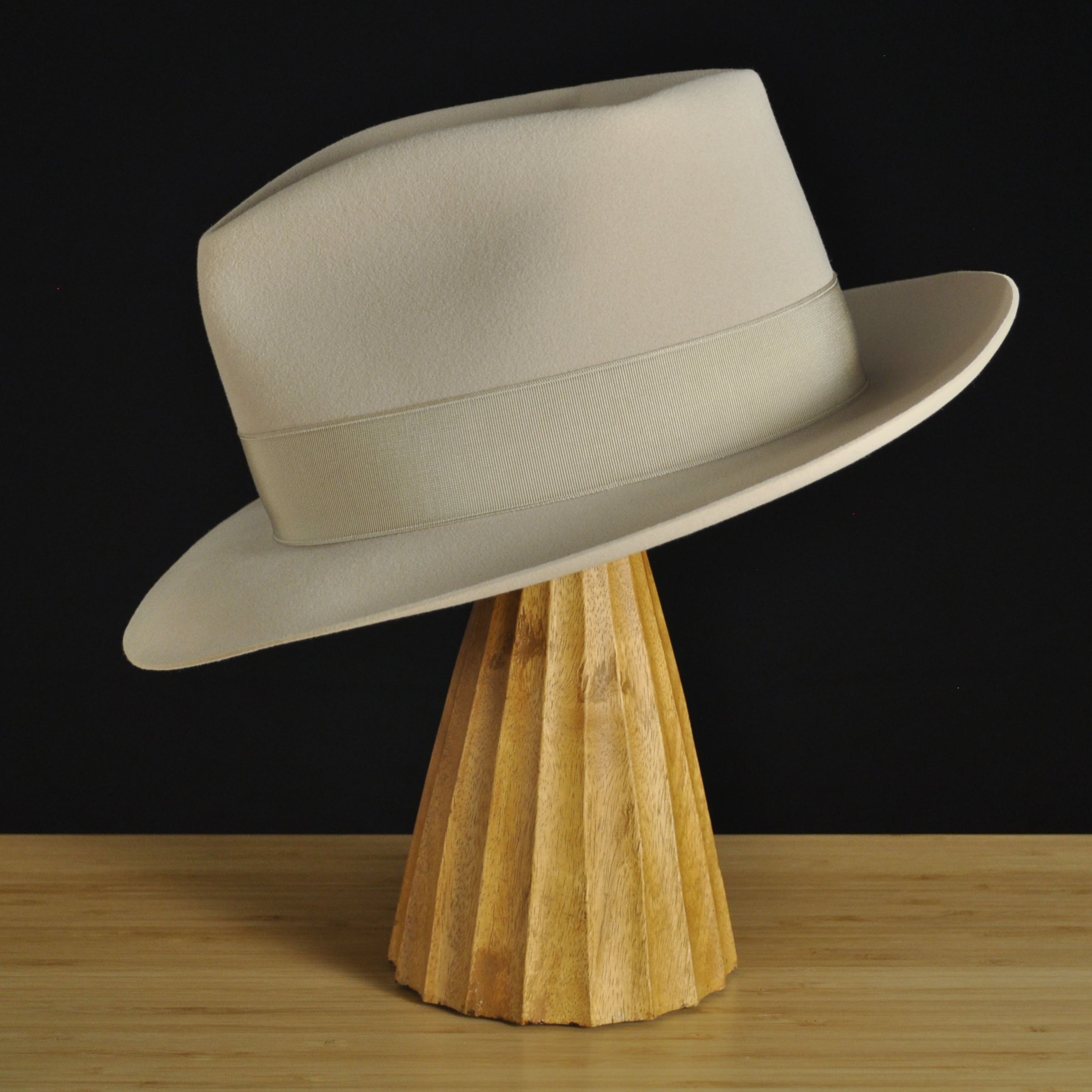 Left view of The Vintner ivory felt fedora with a softly pinched crown, medium snap brim, and matching ivory grosgrain ribbon with classic double bow.