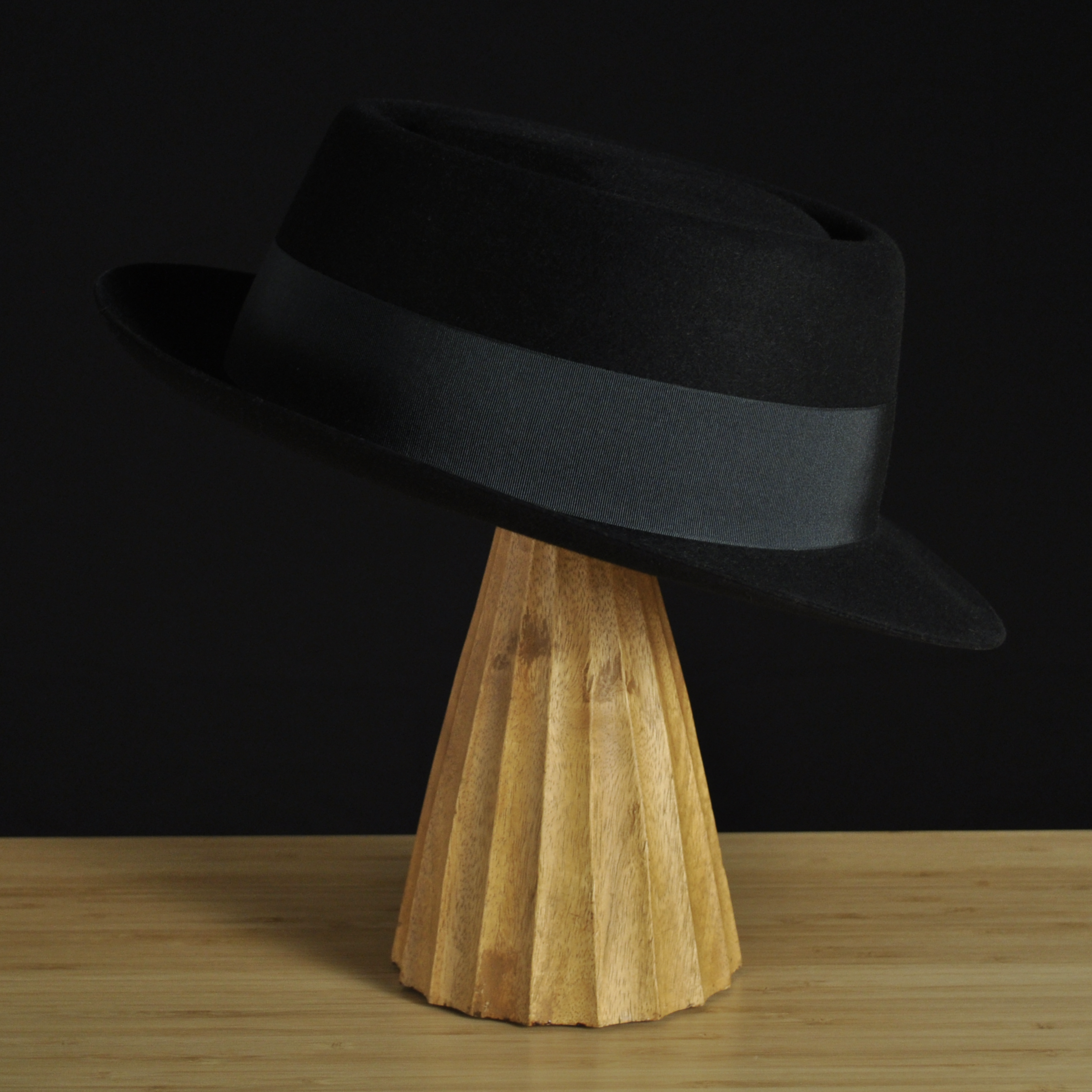 Right view of The Midtowner black felt fedora with a clean tapered crown, medium snap brim, and matching black grosgrain ribbon with classic bow.
