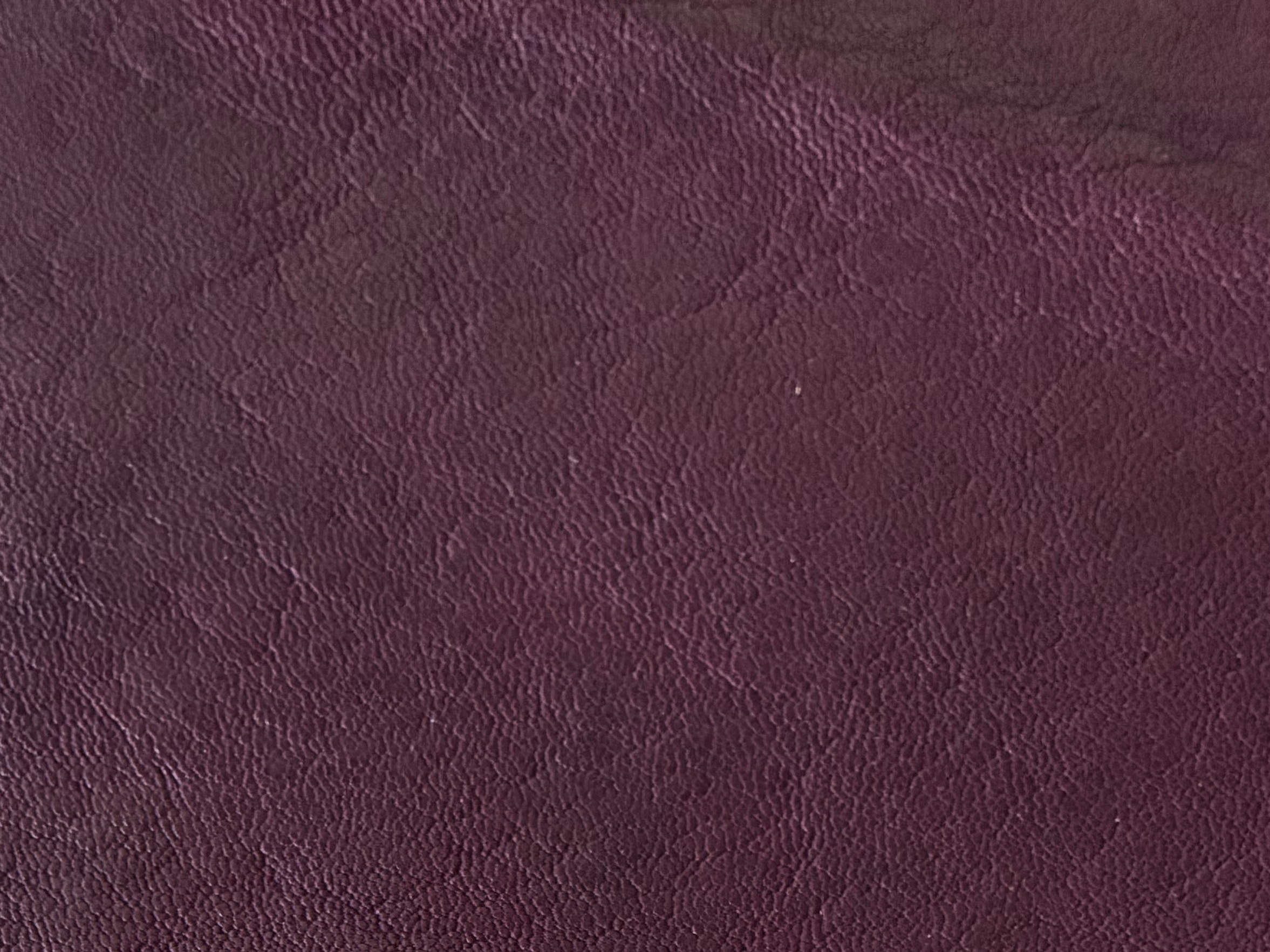 Primer plano de superficie de cuero texturizado burdeos.