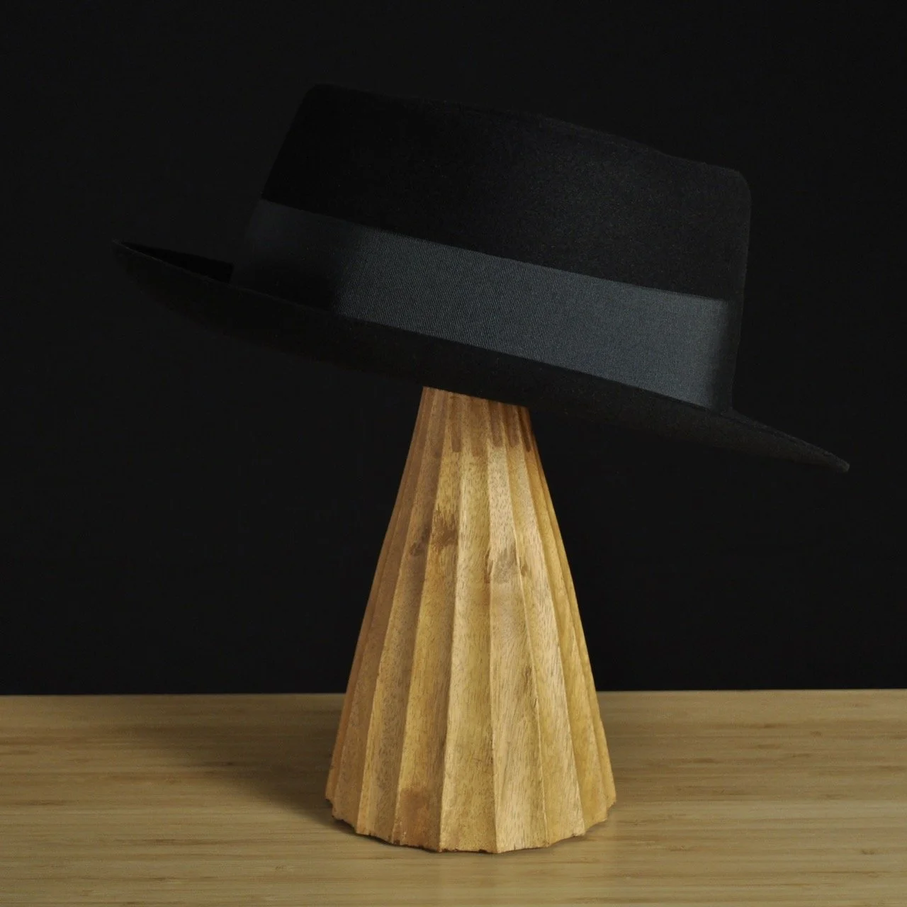 - Three-quarter rear right view of The Midtowner black felt fedora with a clean tapered crown, medium snap brim, and matching black grosgrain ribbon with classic bow.