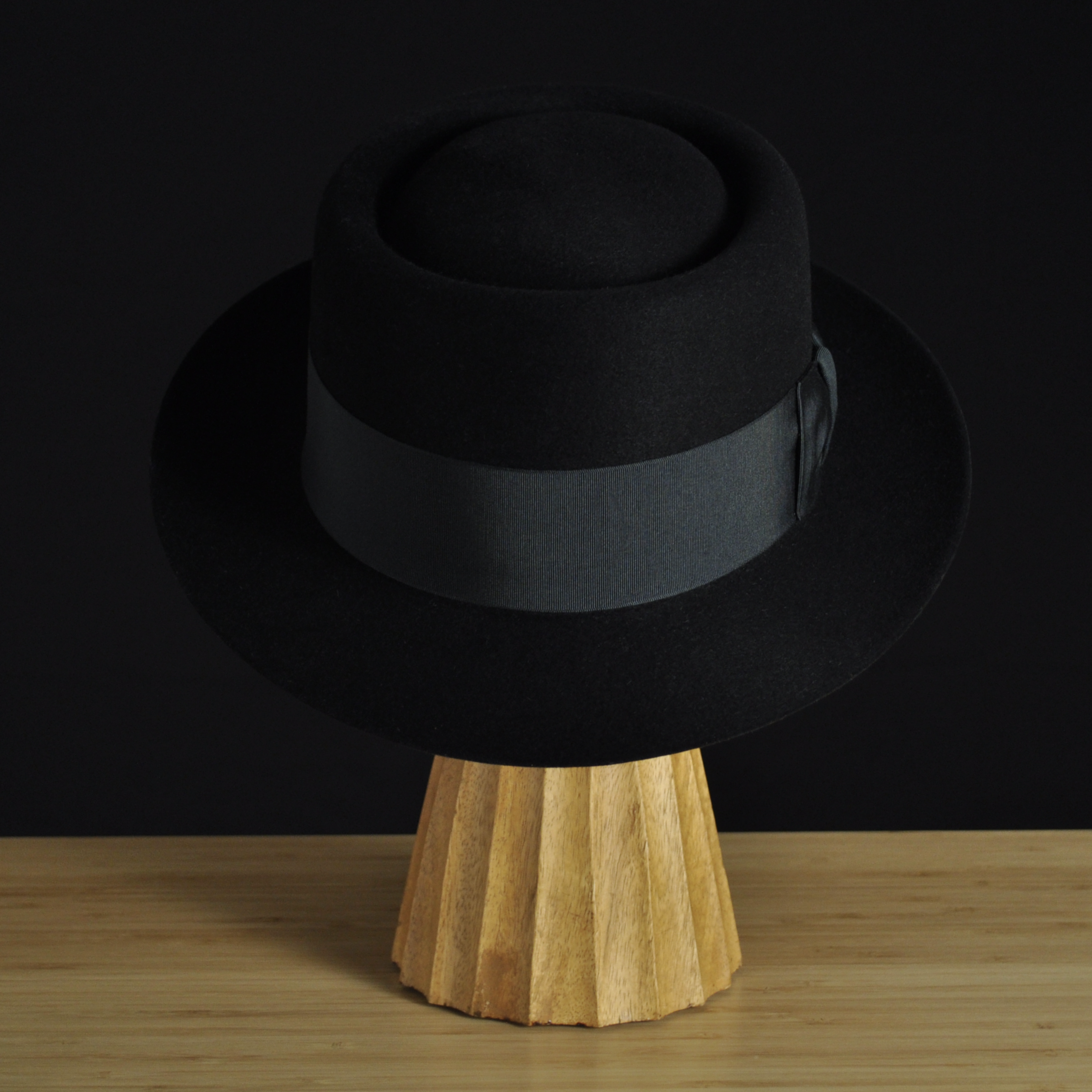 Front view of The Midtowner black felt fedora with a clean tapered crown, medium snap brim, and matching black grosgrain ribbon with classic bow.