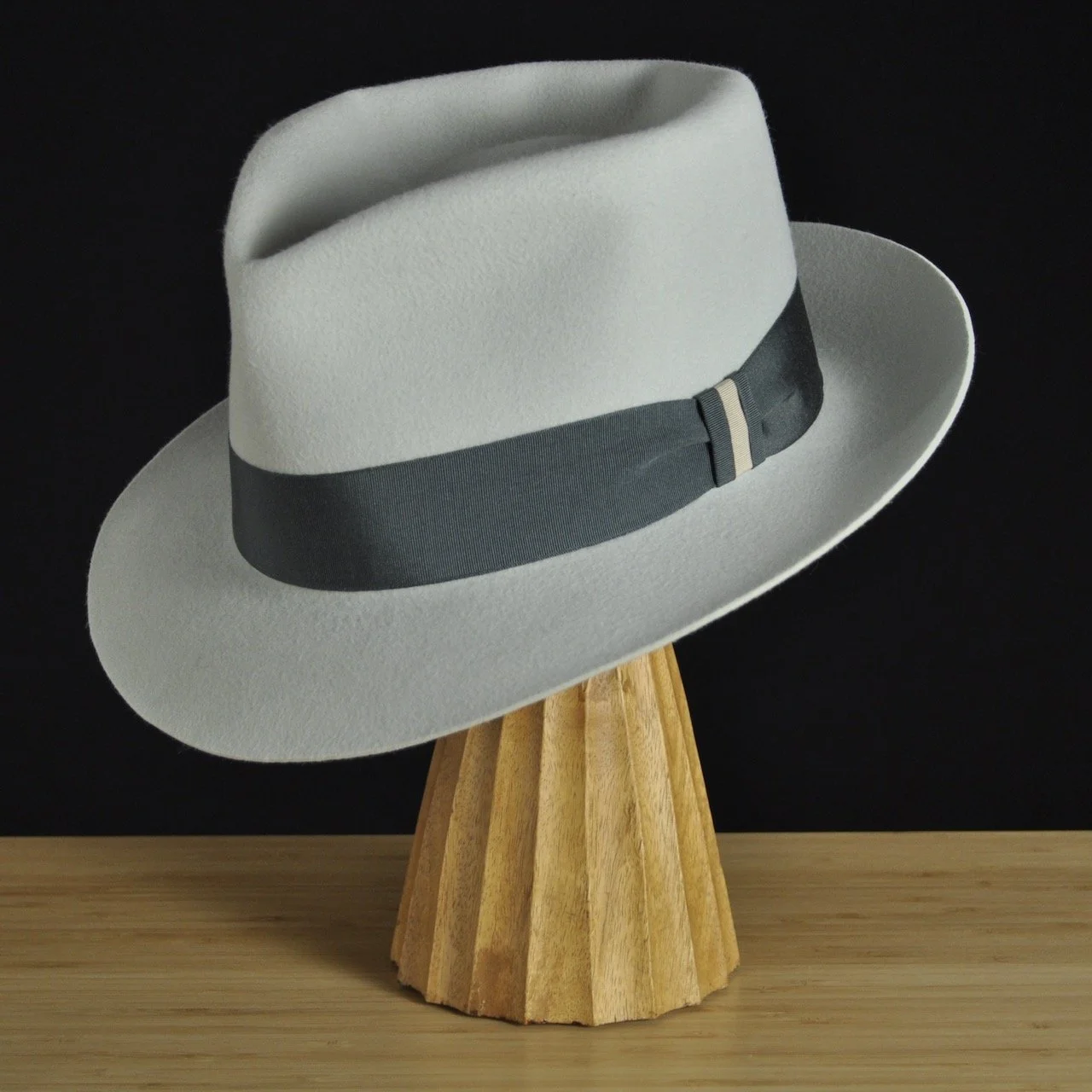 Three-quarter front left view of The Sunsetter silvermist felt fedora with a softly pinched crown, medium snap brim, and contrasting dark grosgrain ribbon with a modern tie (no bow).