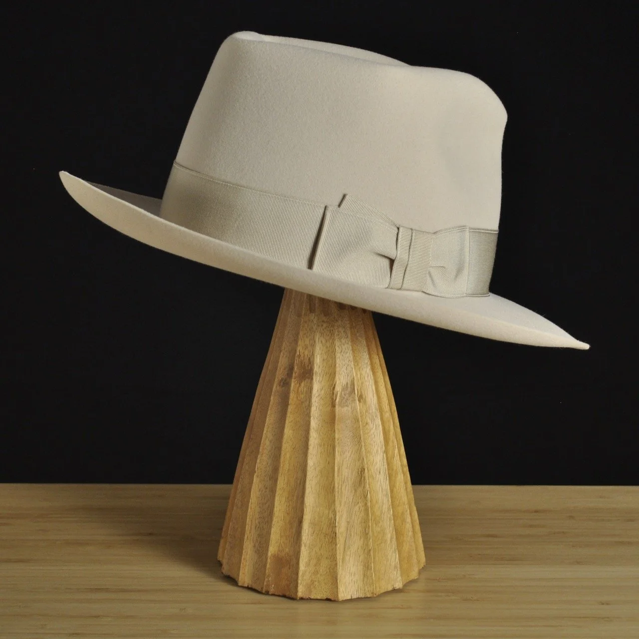Three-quarter rear left view of The Vintner ivory felt fedora with a softly pinched crown, medium snap brim, and matching ivory grosgrain ribbon with classic double bow.