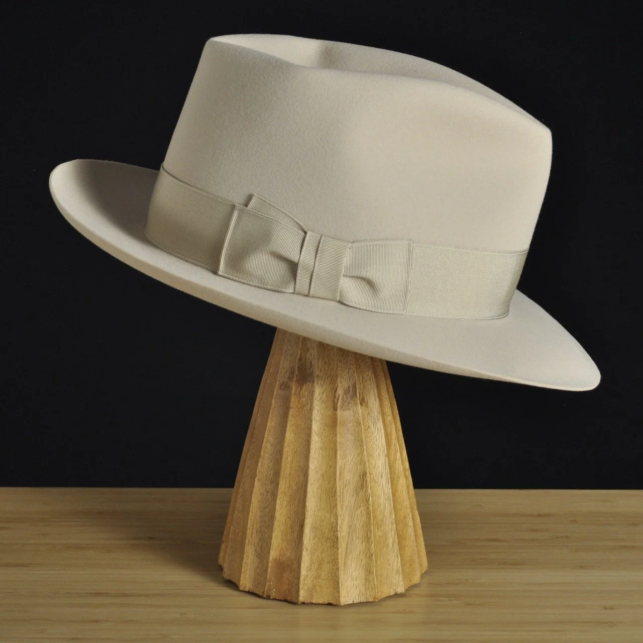 Left view of The Vintner ivory felt fedora with a softly pinched crown, medium snap brim, and matching ivory grosgrain ribbon with classic double bow.