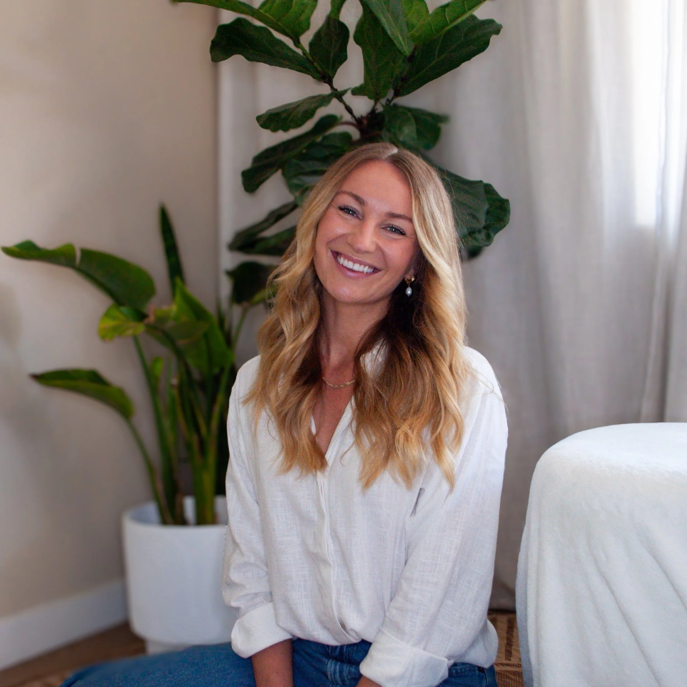 San Diego IFS therapist and founder of Holistic Flow Therapy smiling warmly in a calm therapy office setting