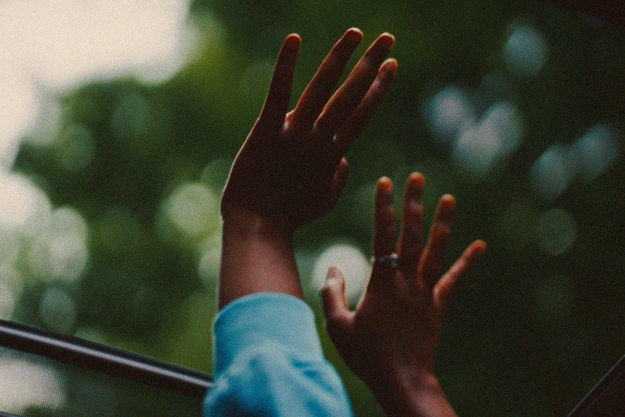 Hands through car sun roof.png
