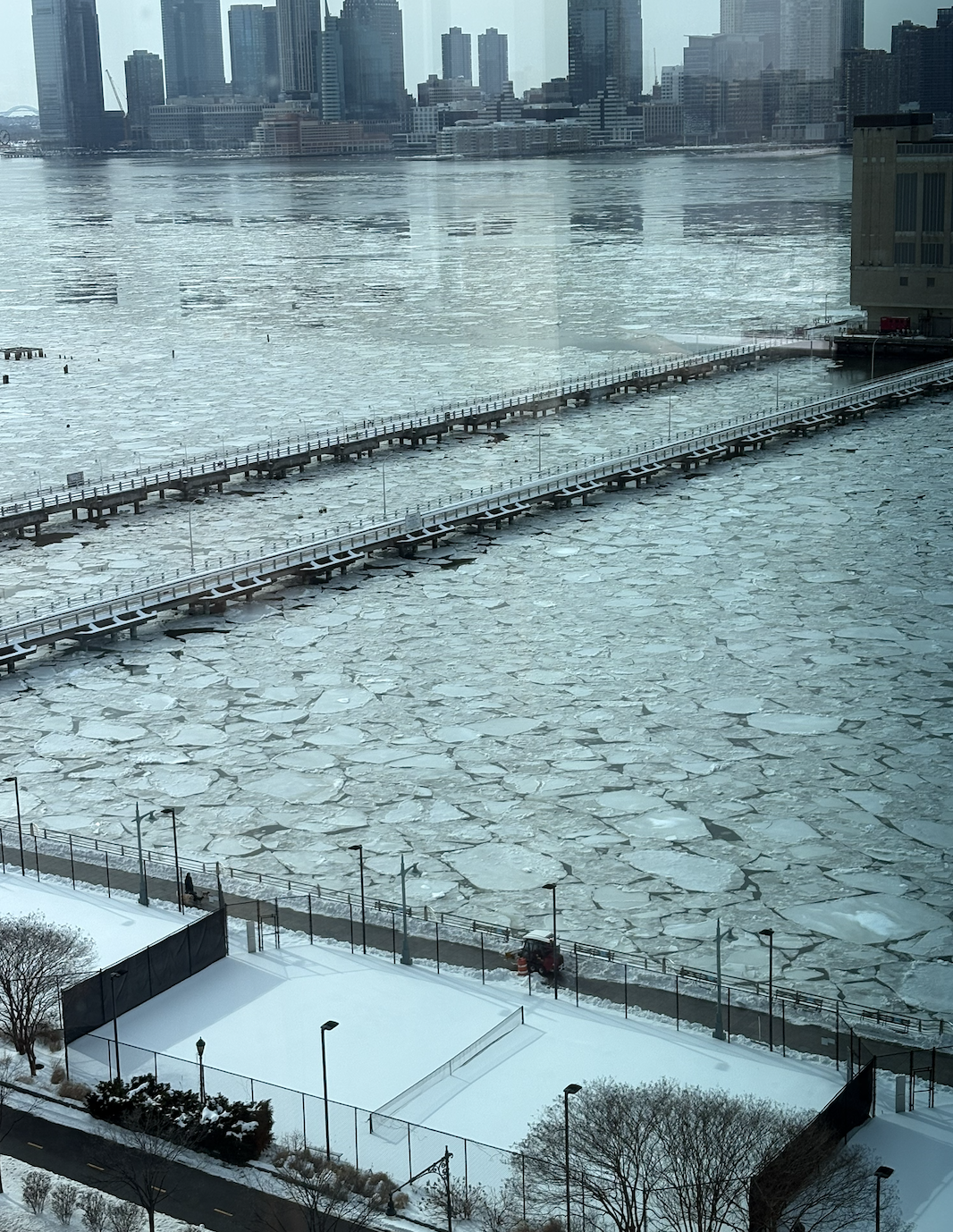 sheets of broken ice water in the harbor with New York City in the background
