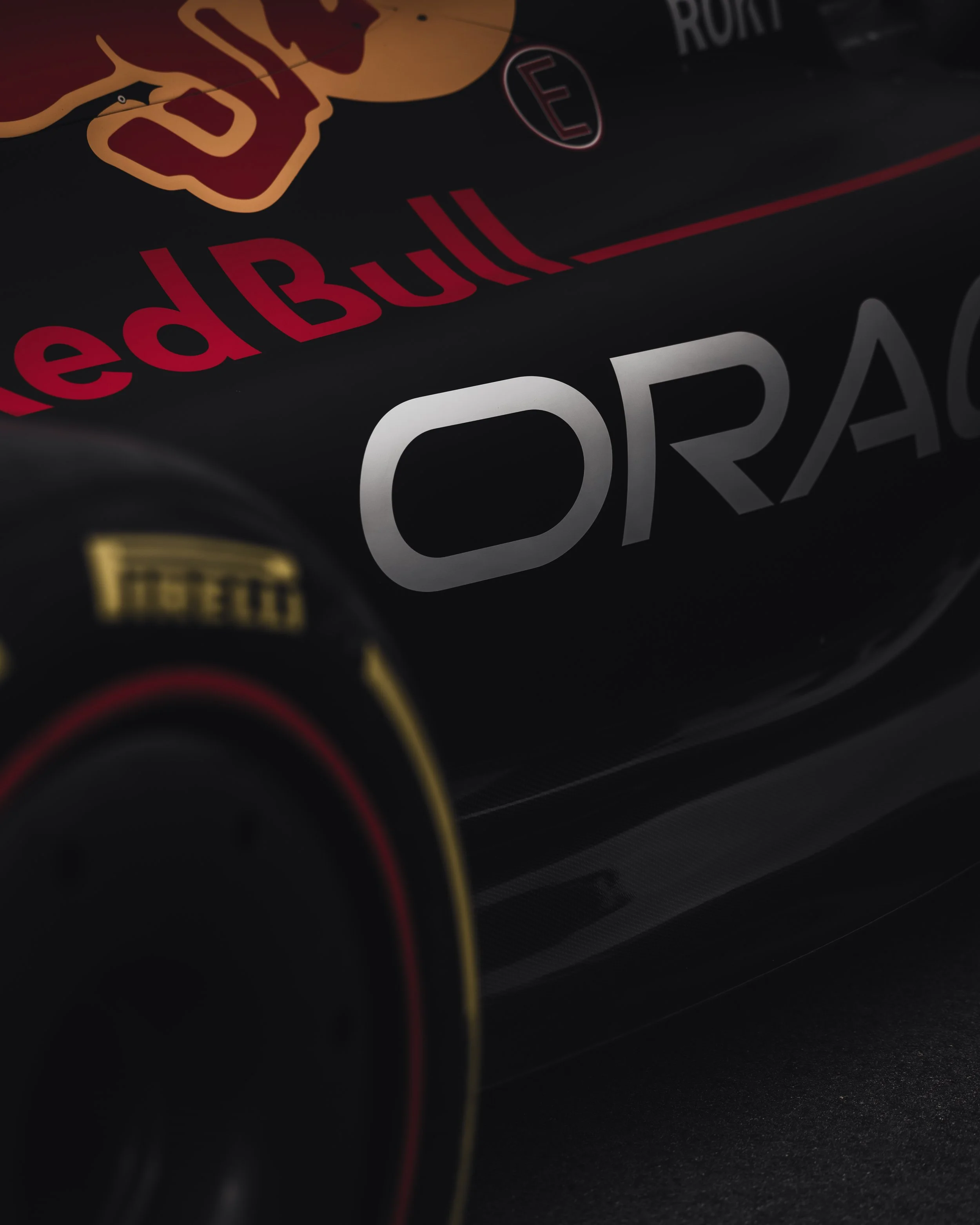 Close-up of a red bull racing energy drink can showcasing the logo and brand name in red, white, and yellow text on a black background.