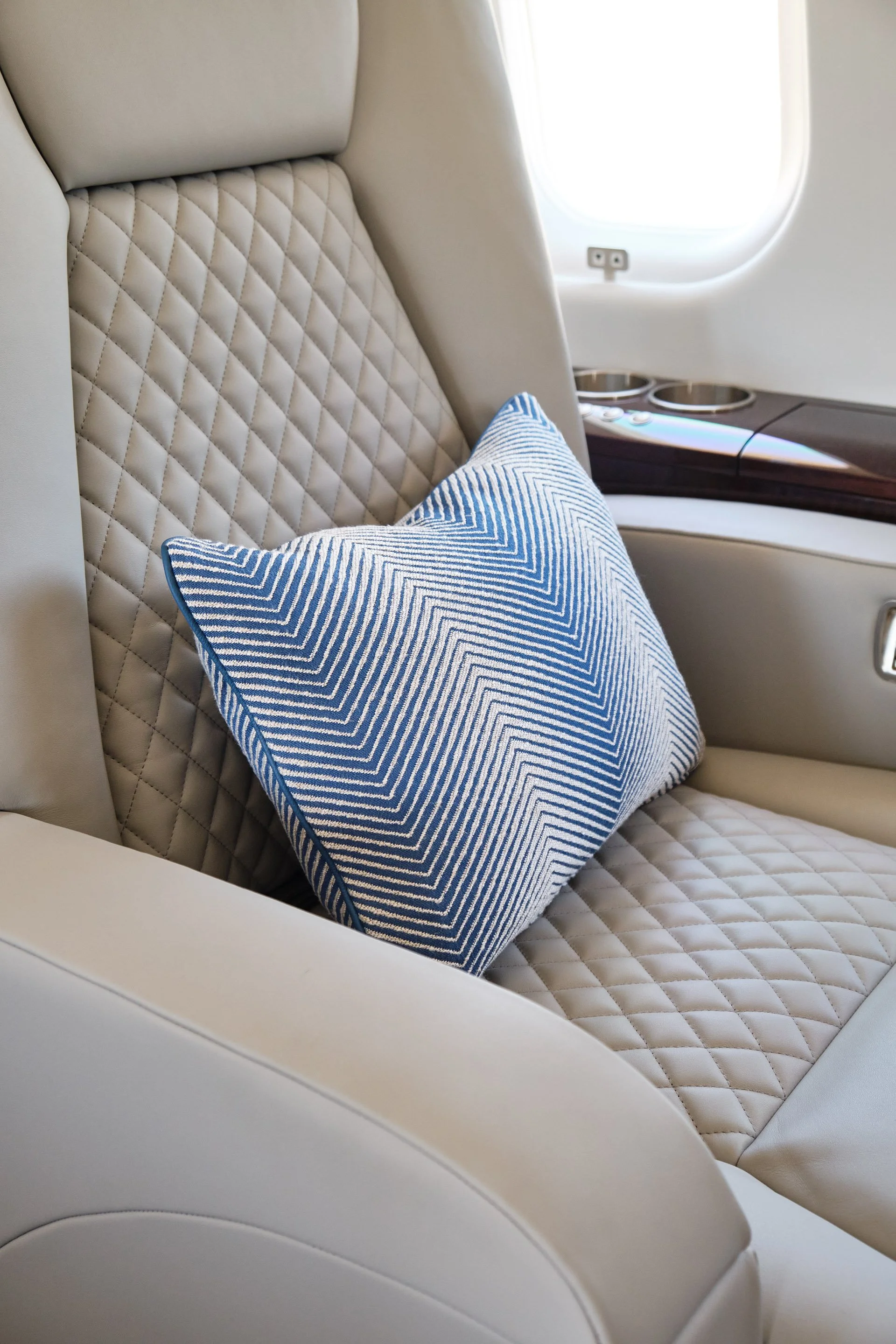 ACD | Alicia Cheung Design detailed this quilted leather seat with a chevron-patterned custom pillow, creating a tailored and textural moment perfect for showcasing the cabin's fabric selections.