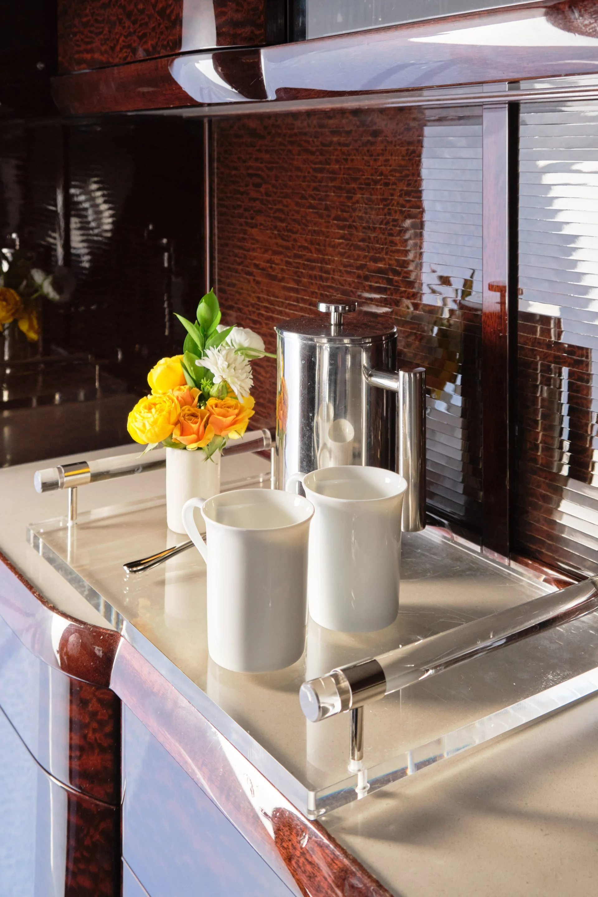 ACD | Alicia Cheung Design detailed this coffee service against the aircraft's original burl wood paneling, pairing polished silver with fresh florals, creating a warm and hospitable moment perfect for a morning flight.