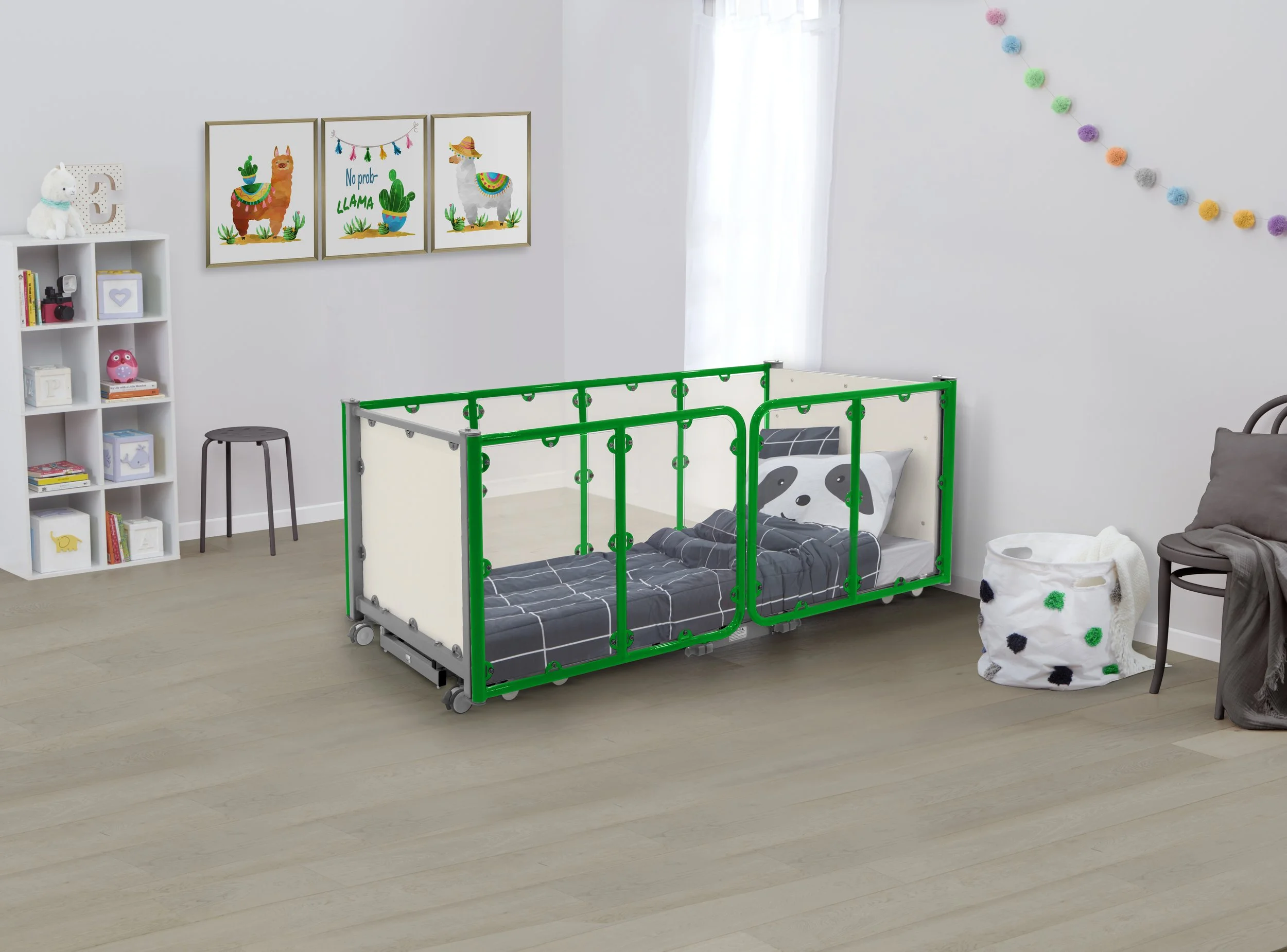 Children's bedroom with a toddler bed featuring green safety rails, panda-themed bedding, a wall shelf with toys and books, colorful decorative wall art of llamas, and a polka dot laundry basket.