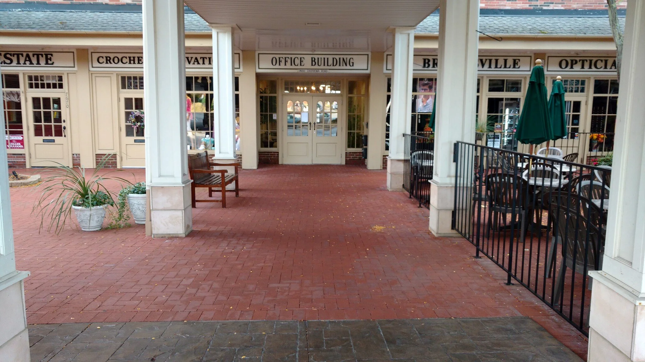 Walkway to main office building doors. Through a courtyard surrounded by other businesses.