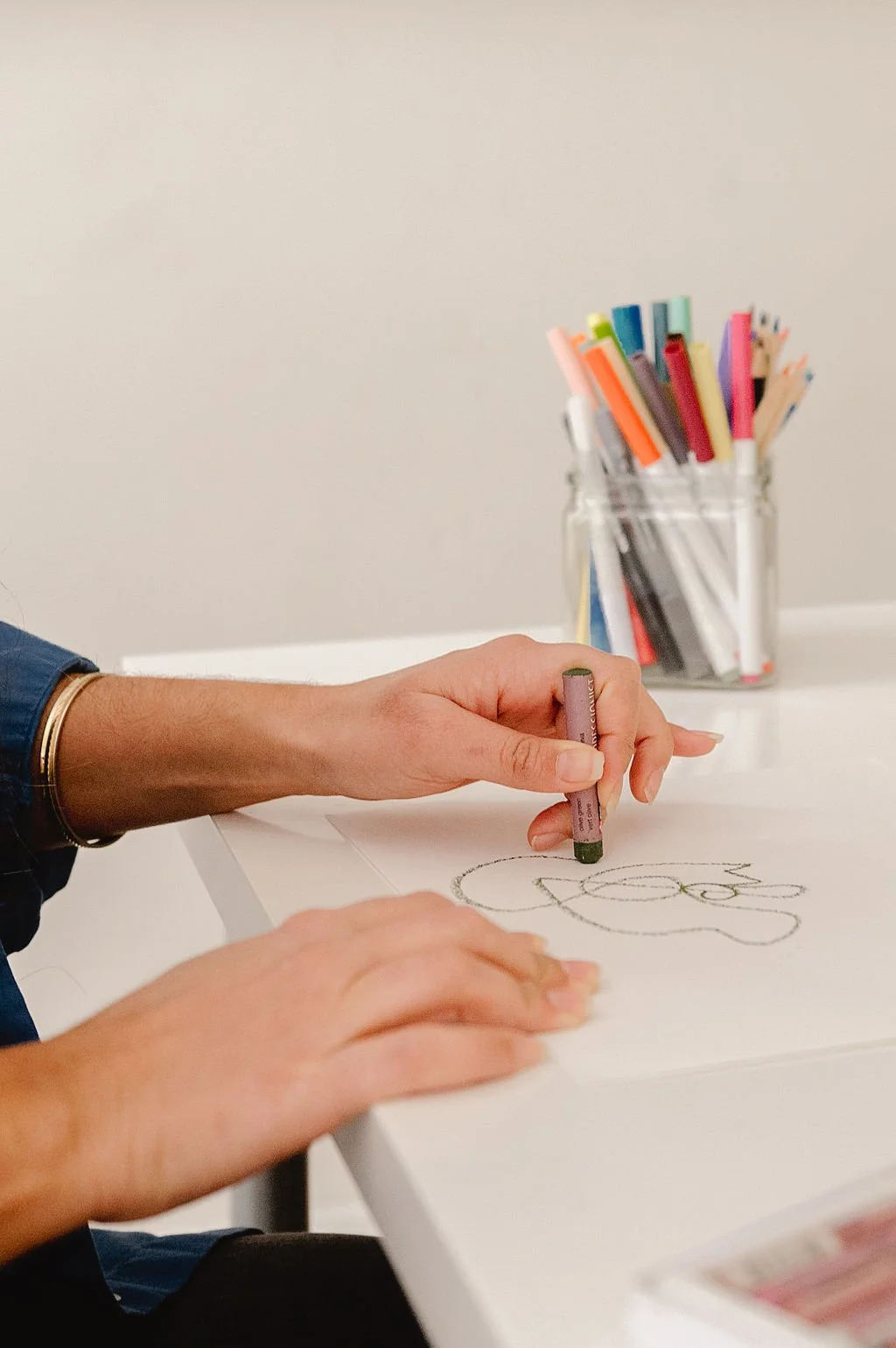 Person scribbling with oil pastels in art therapy session.