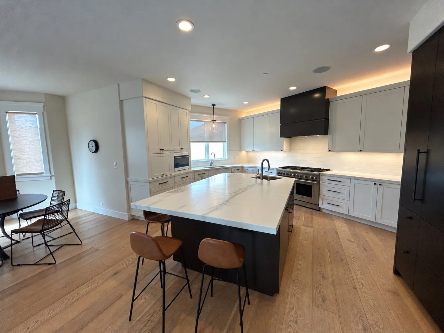 Remodeled kitchen with a spacious stone island, two-tone cabinetry, and modern appliances.