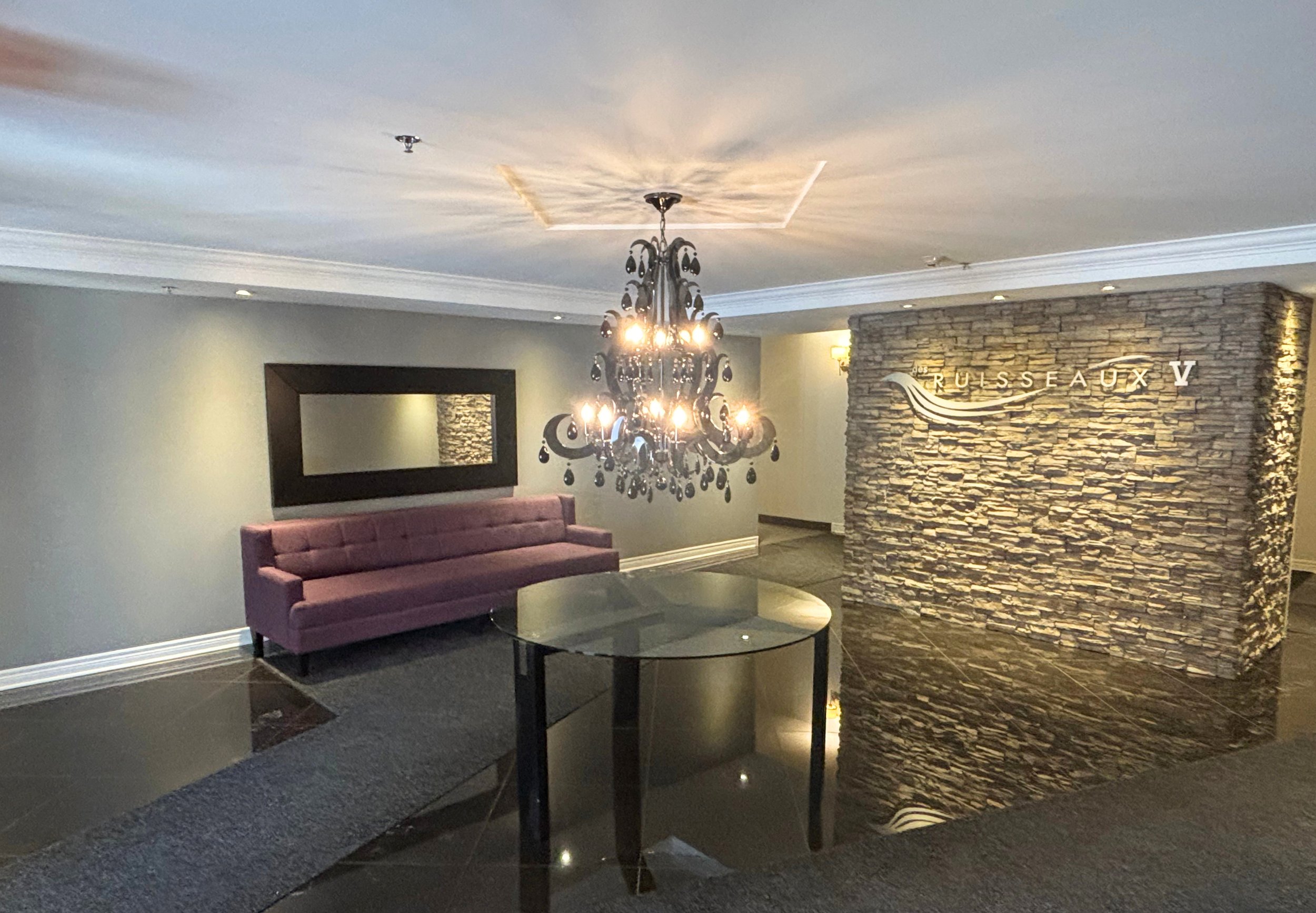 Vestibule de l'immeuble Des Ruisseaux V à Laval avec lustre et mobilier entièrement protégés avant la peinture des espaces communs