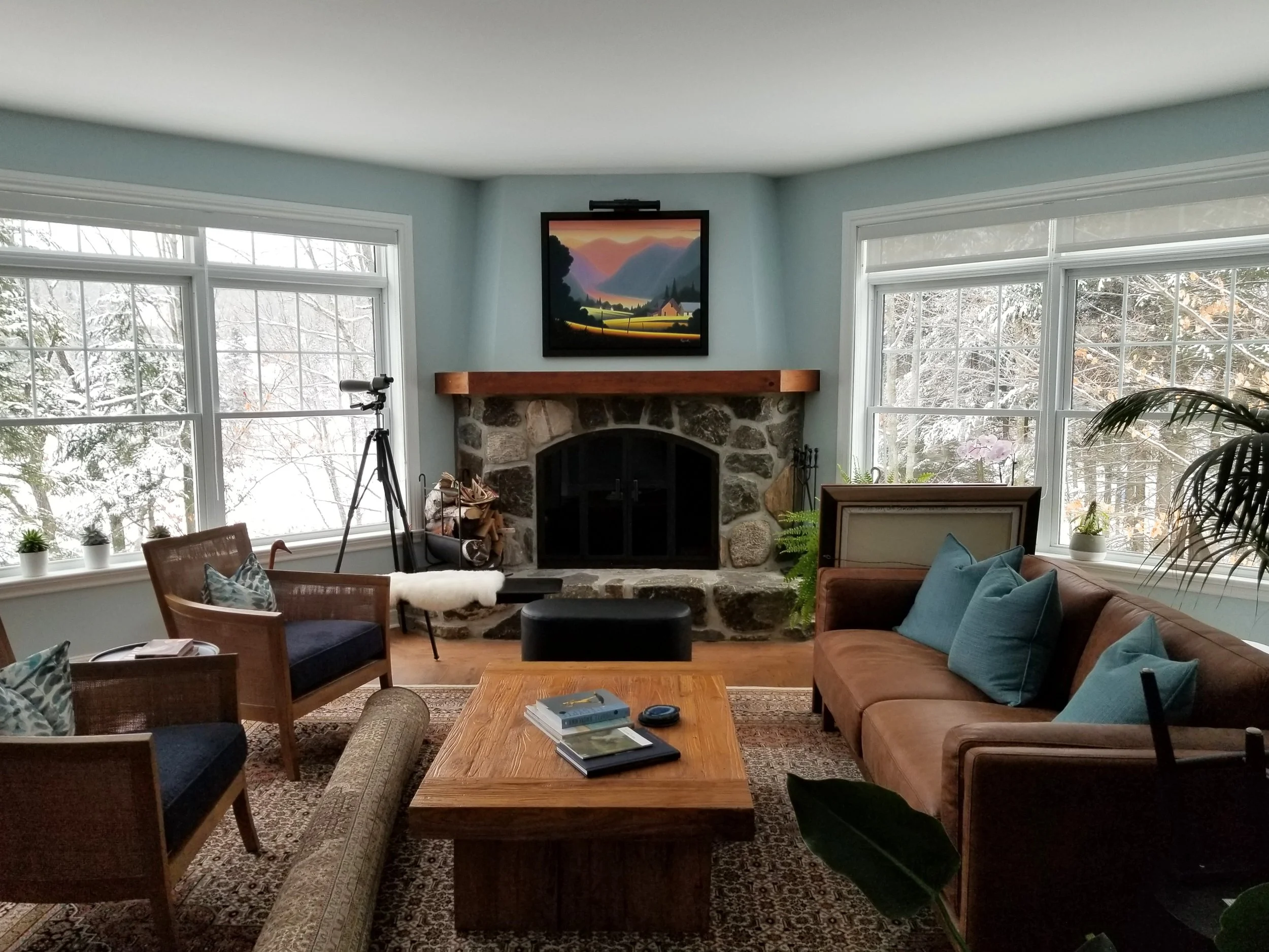 Salon avec foyer de pierre et murs repeints en bleu Air d'océan dans une maison à Blainville