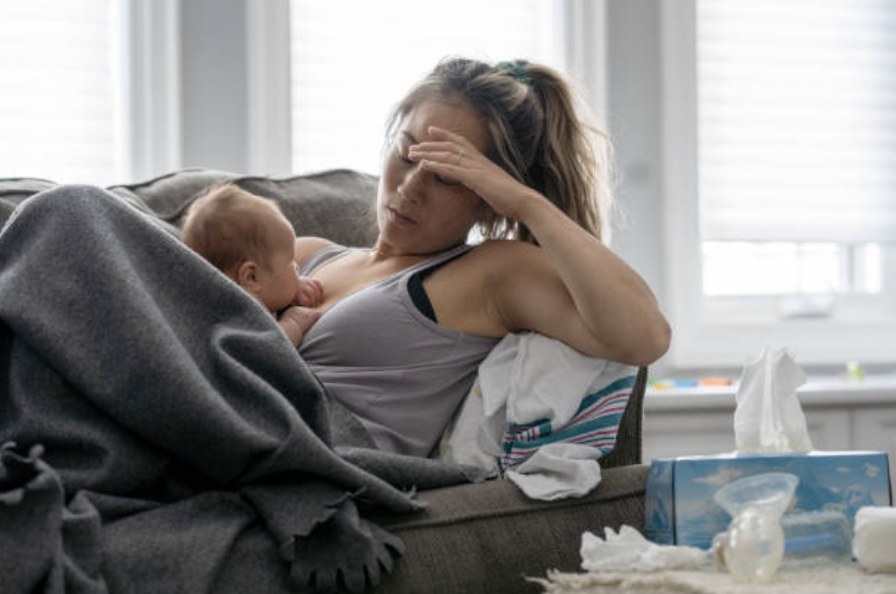 sick mom with mastitis on couch with baby