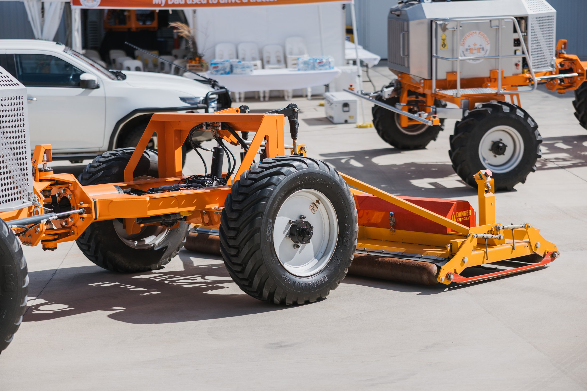Industrial agricultural machinery with large wheels in an outdoor setting.