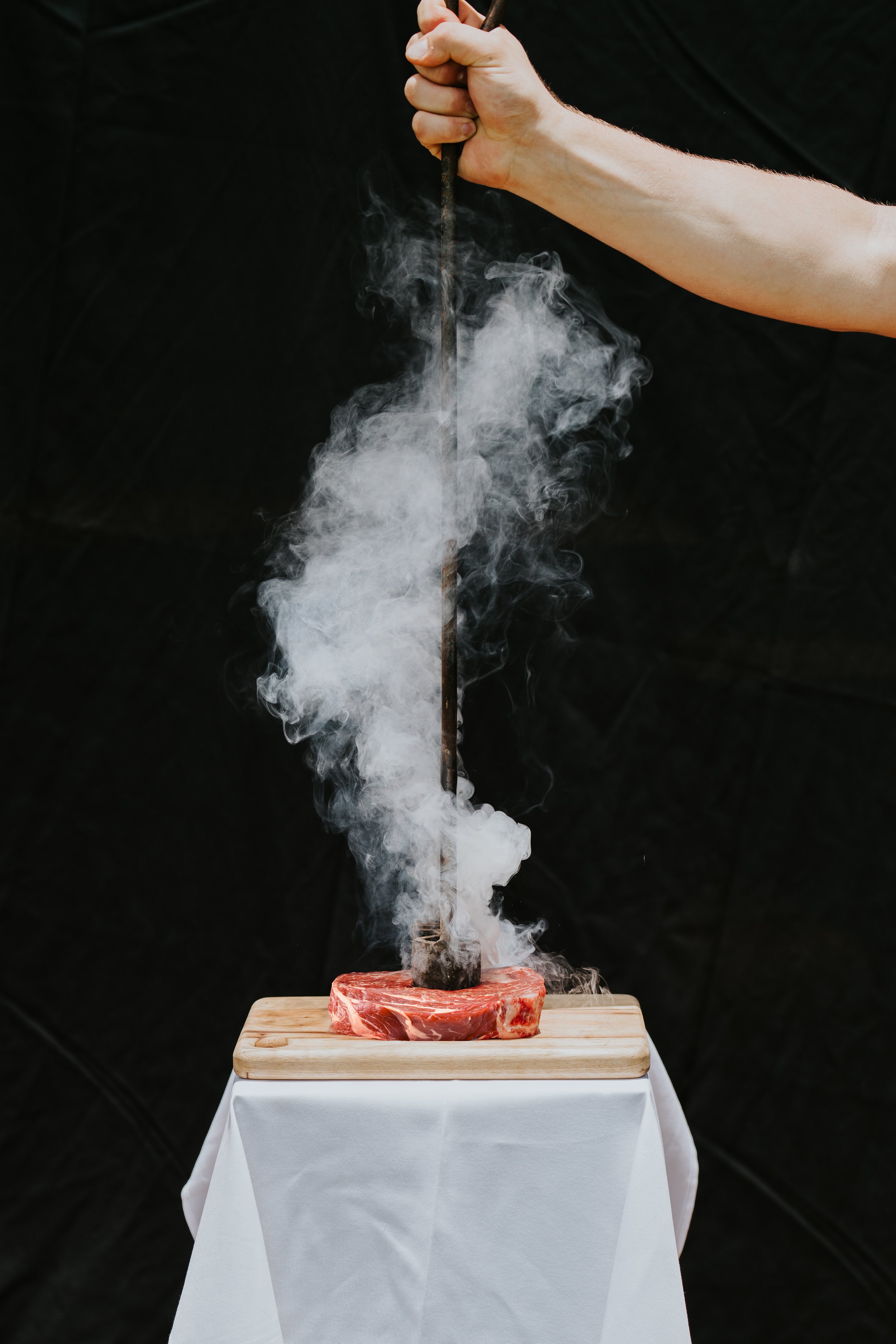 Person using branding iron on steak
