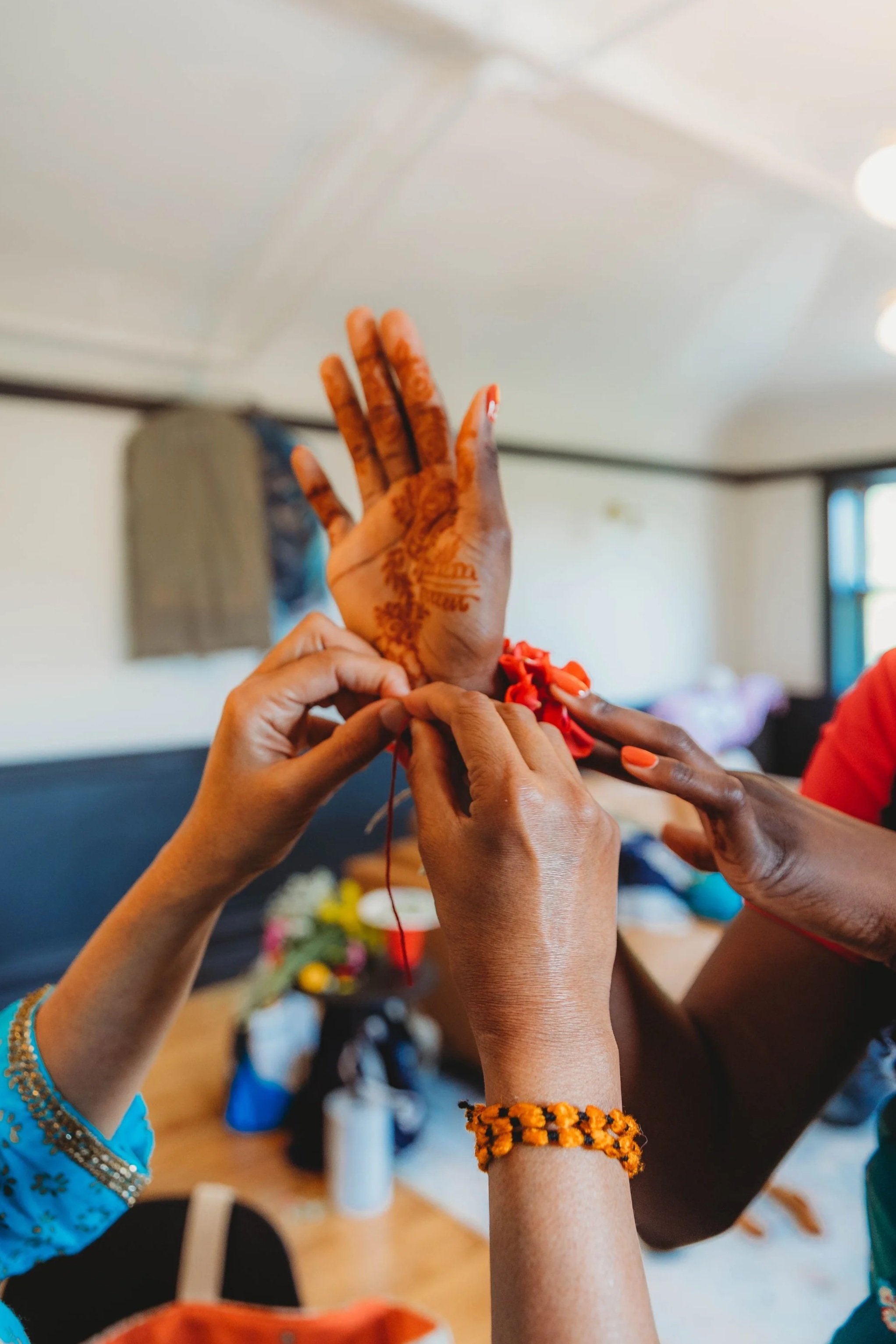 Friends placing gajra on wrists during summer wedding in Chicago. Fresh floral gajra by naazuk studio.