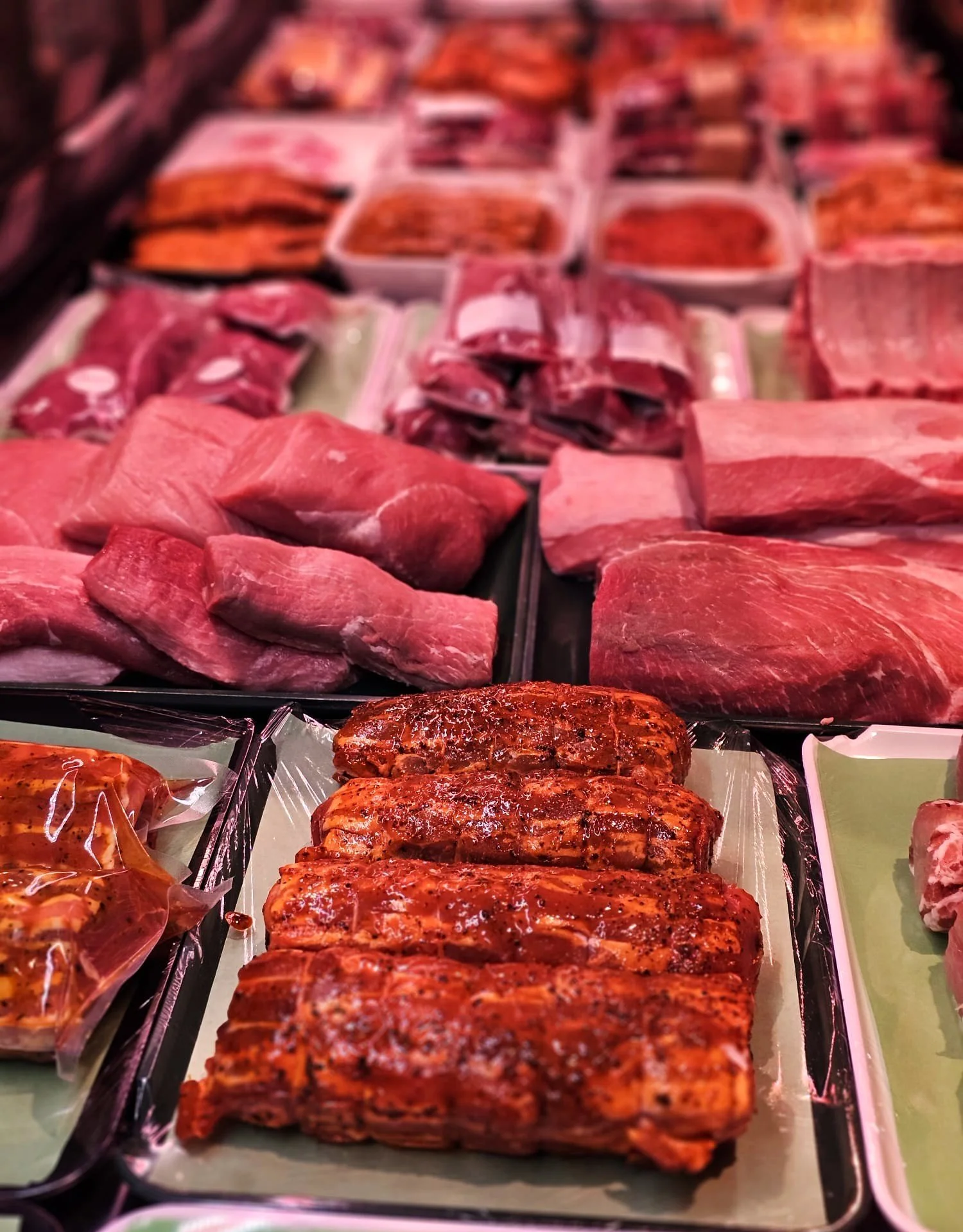 Verschiedene frische Fleischstücke, darunter Rind- und Schweinefleisch, in einer Metzgerei