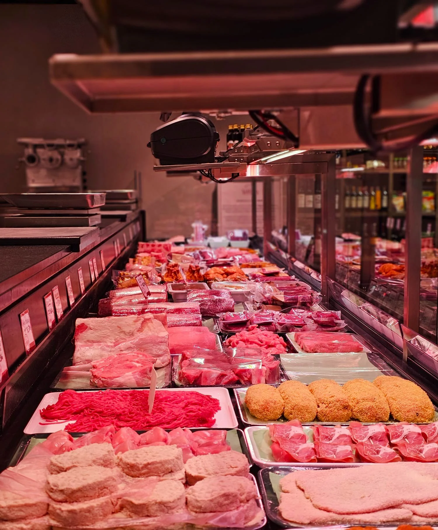 Verschiedene Fleischsorten und paniertes Fleisch in einem Delikatess-Fleischgeschäft